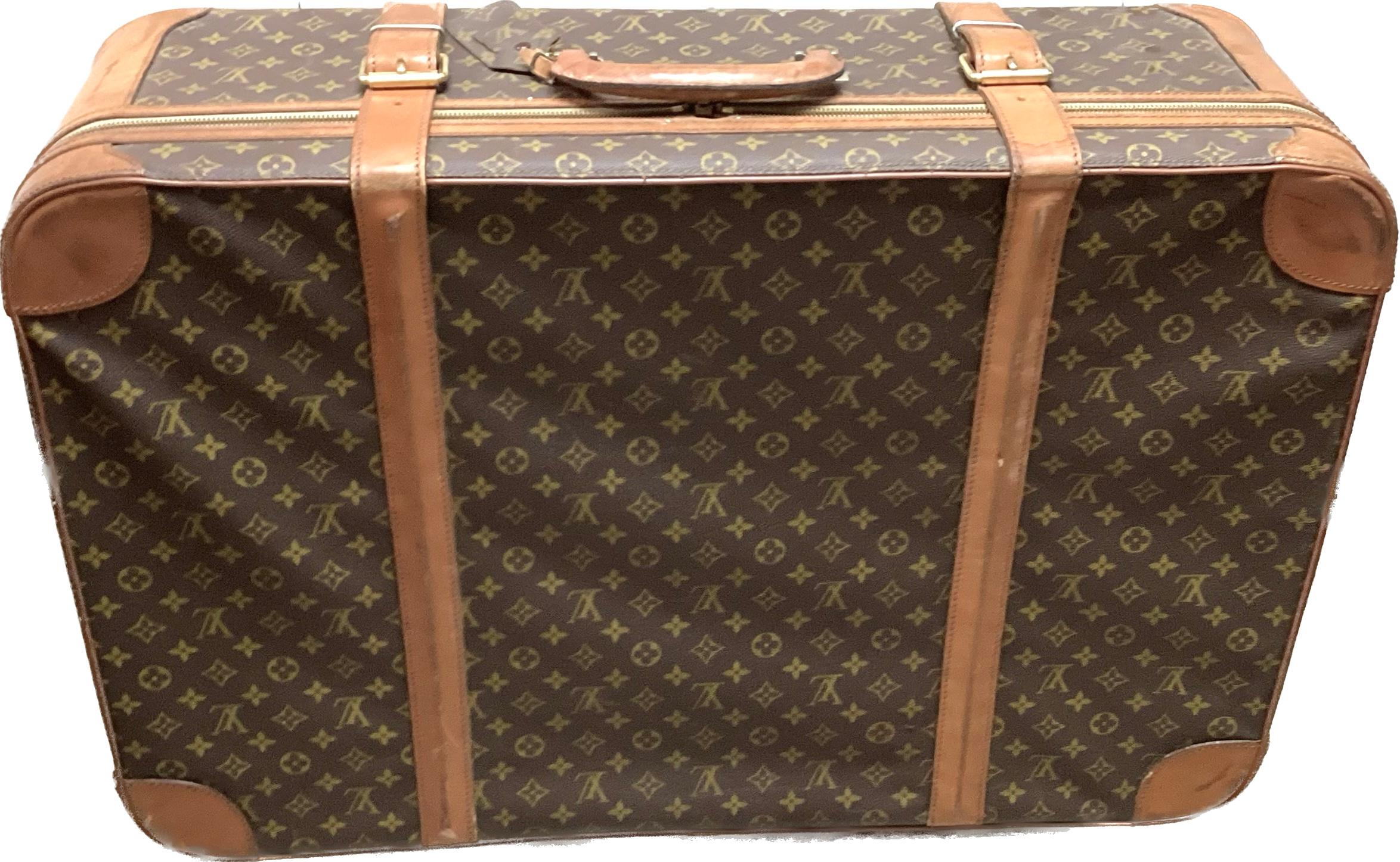 Large Vintage Louis Vuitton leather suitcase. This beautiful piece of luggage features a round top handle and buckle fastenings. Cream colored inside fabric is in good condition and has two side pockets and buckle fastenings. Lock and key included.