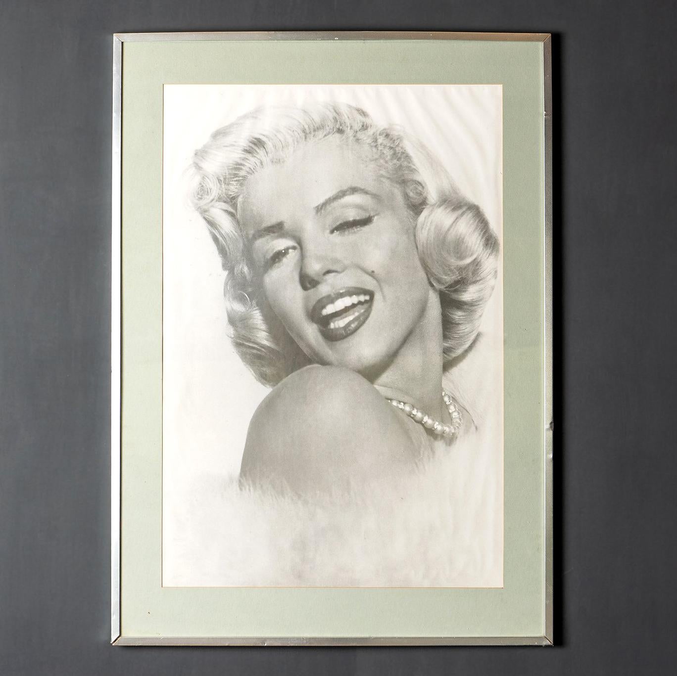 Affiche photographique du milieu du siècle

L'icône Marilyn y est représentée avec une coiffure et un maquillage typiques, un collier de perles, une étole de fourrure blanche et cette lueur si familière dans ses yeux.

La photographie date de 1953,