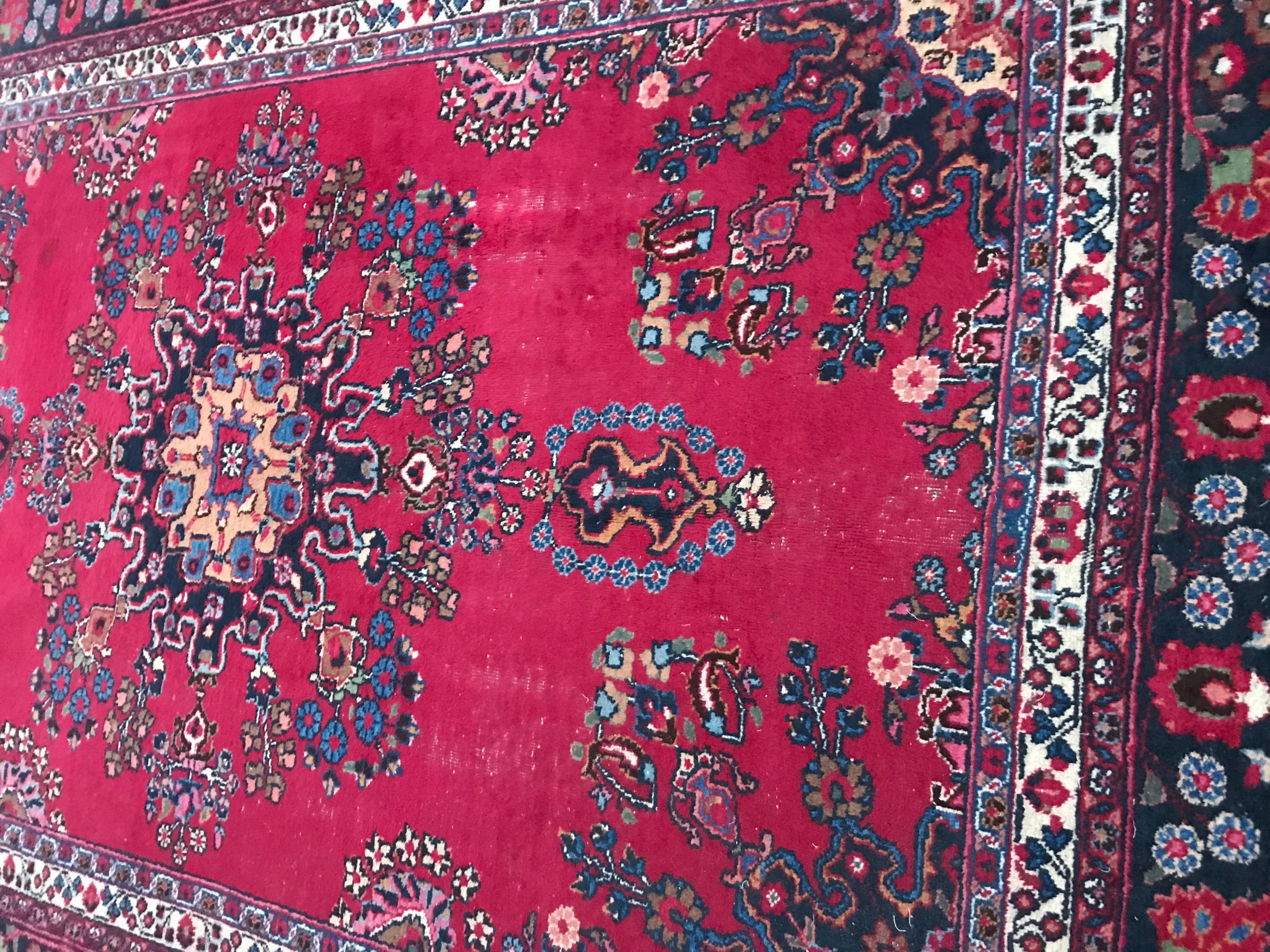 Beautiful mid-20th century rug with a floral design and a central medallion and a red field, blue, yellow, green and pink colors, entirely hand knotted with wool velvet on cotton foundation.
