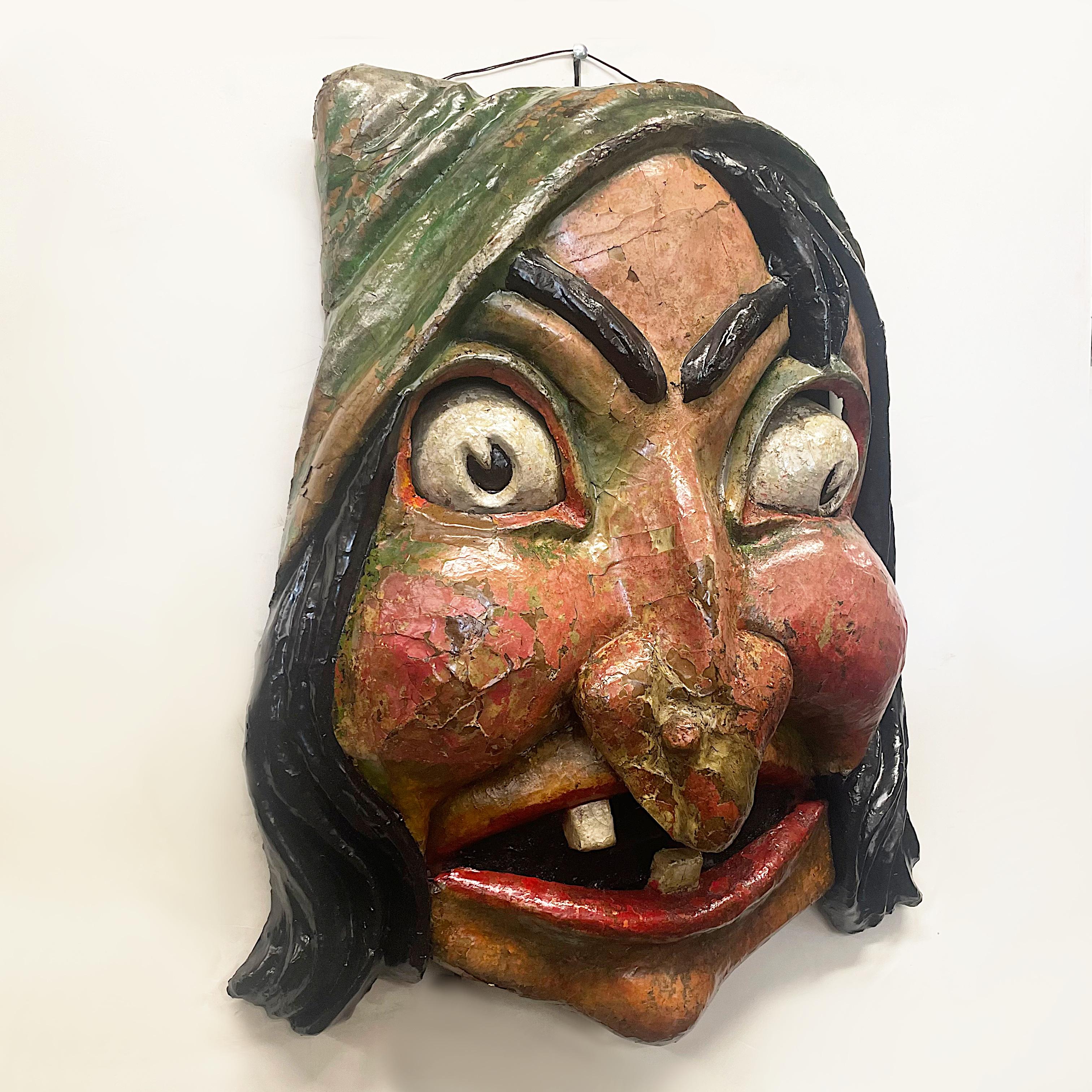 This spectacular papier maché witch head has all the scary facial features one would expect from a witch and was likely originally from a haunted house/carnival installation. Much of the original paint remains but there is obvious flaking in some