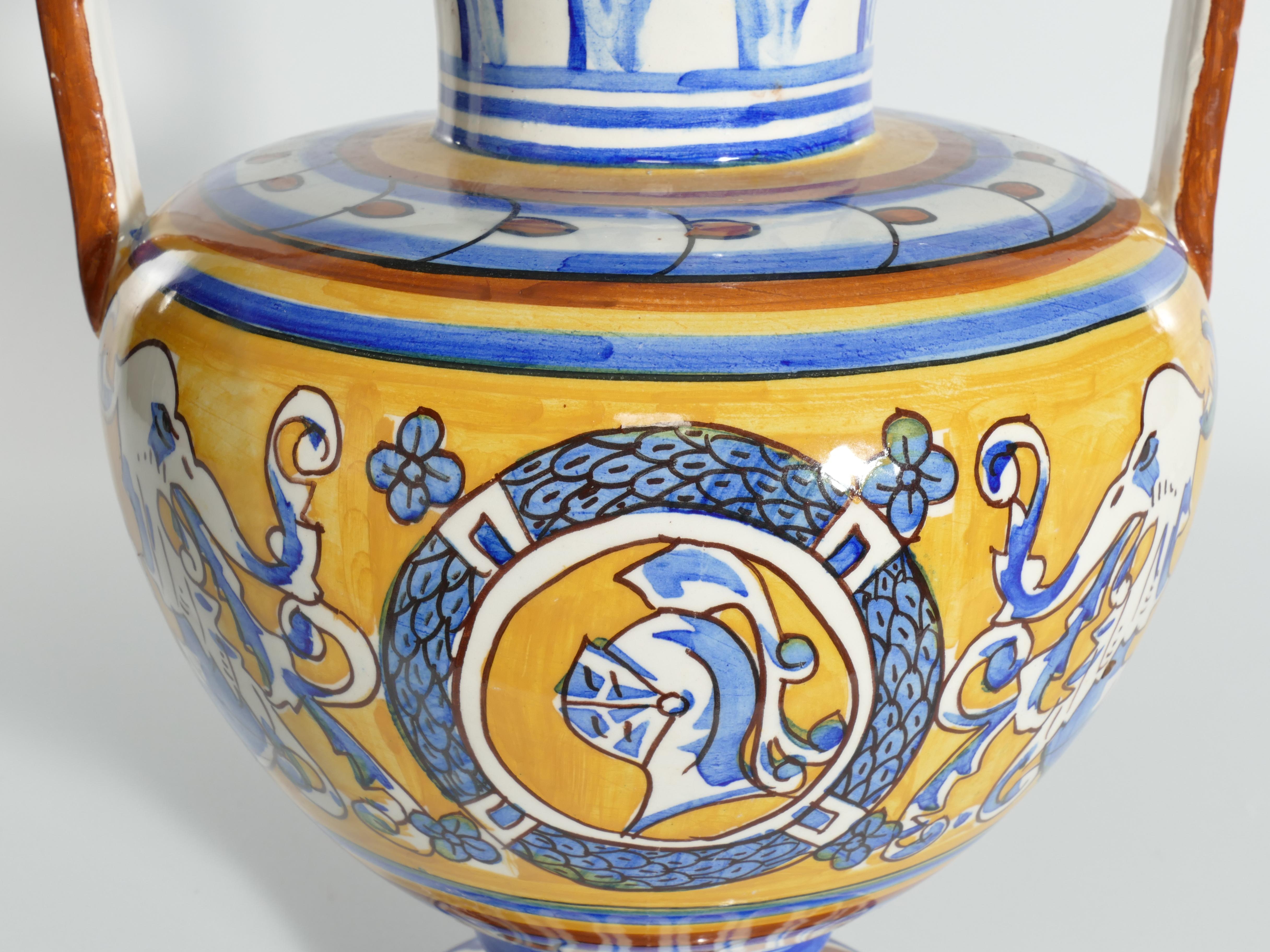 Une paire de grands vases méditerranéens absolument étonnants avec une décoration peinte à la main d'un chevalier et de dragons dans les couleurs traditionnelles de jaune, brun et bleu. Des poignées exceptionnelles avec des figures détaillées. 

Ces
