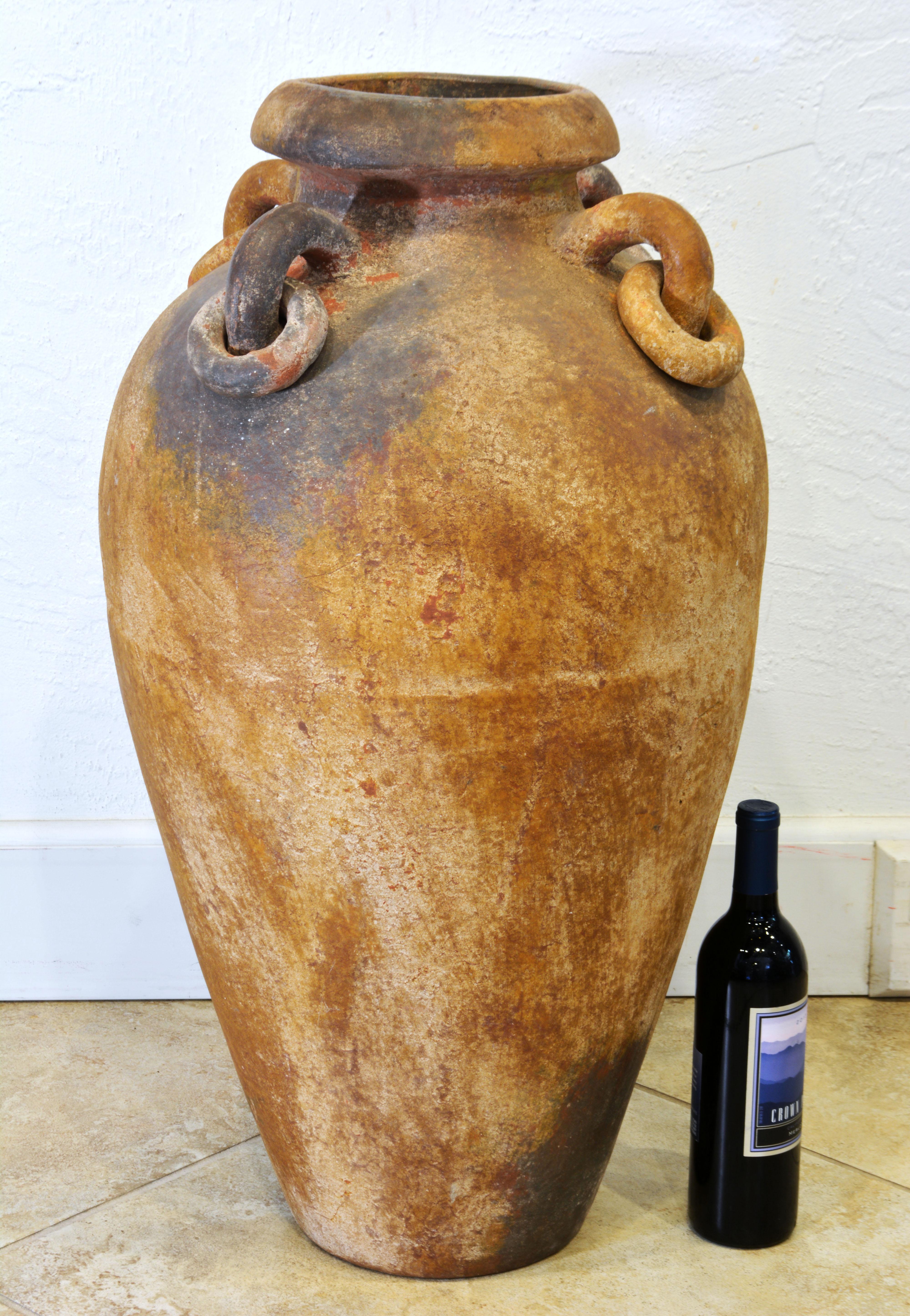 Standing almost 32 inches tall this beautifully patinated terracotta olive jar will make a great impression indoors as well as outdoors. Of classic form It features a wide flared mouth and four ring handles adding a sculptural effect.
