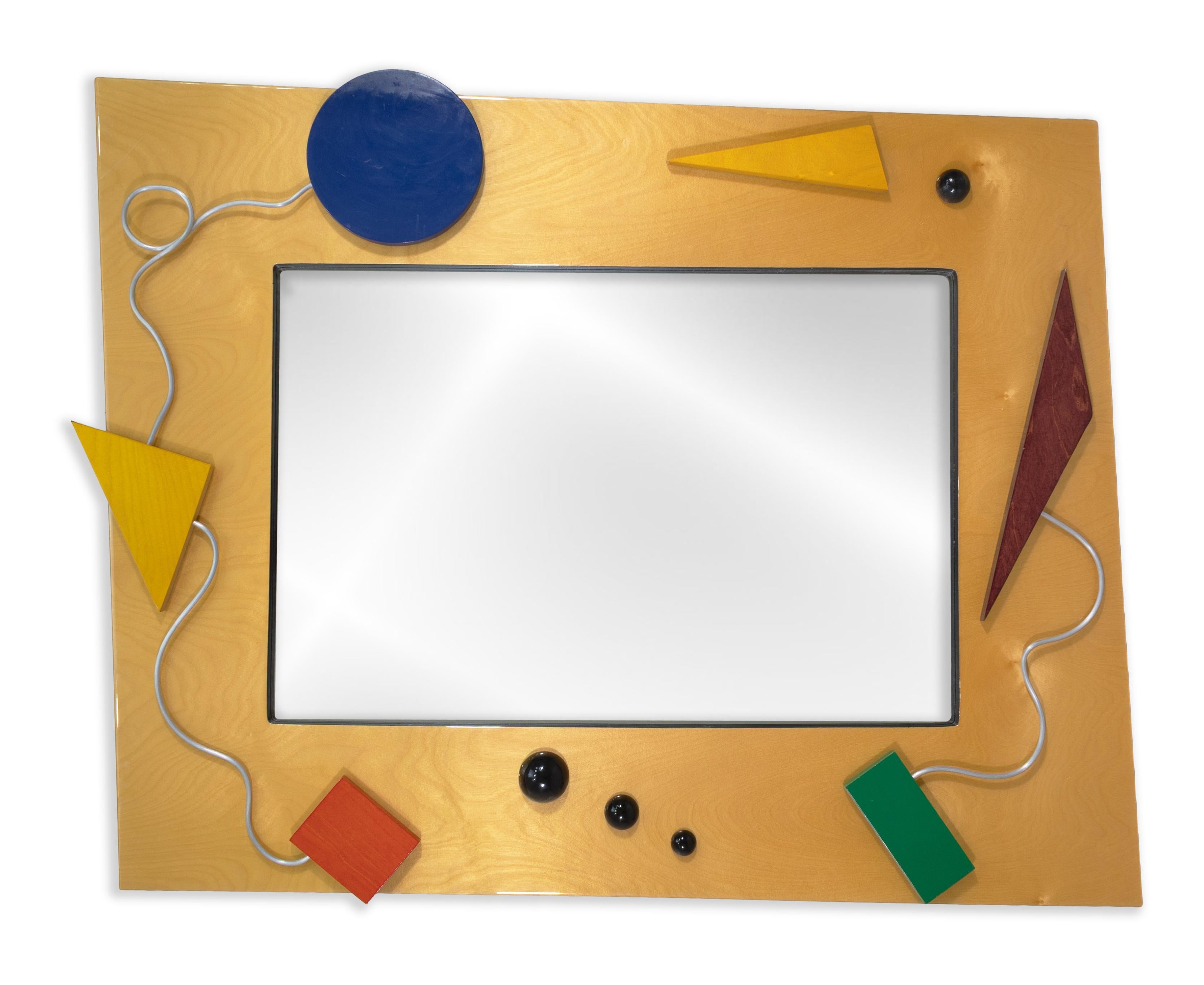 Ce grand miroir mural vintage de style Memphis est une pièce audacieuse, ludique et résolument postmoderne qui incarne l'esprit du design des années 1980. Encadré de bois clair, le miroir présente un mélange éclectique de formes géométriques