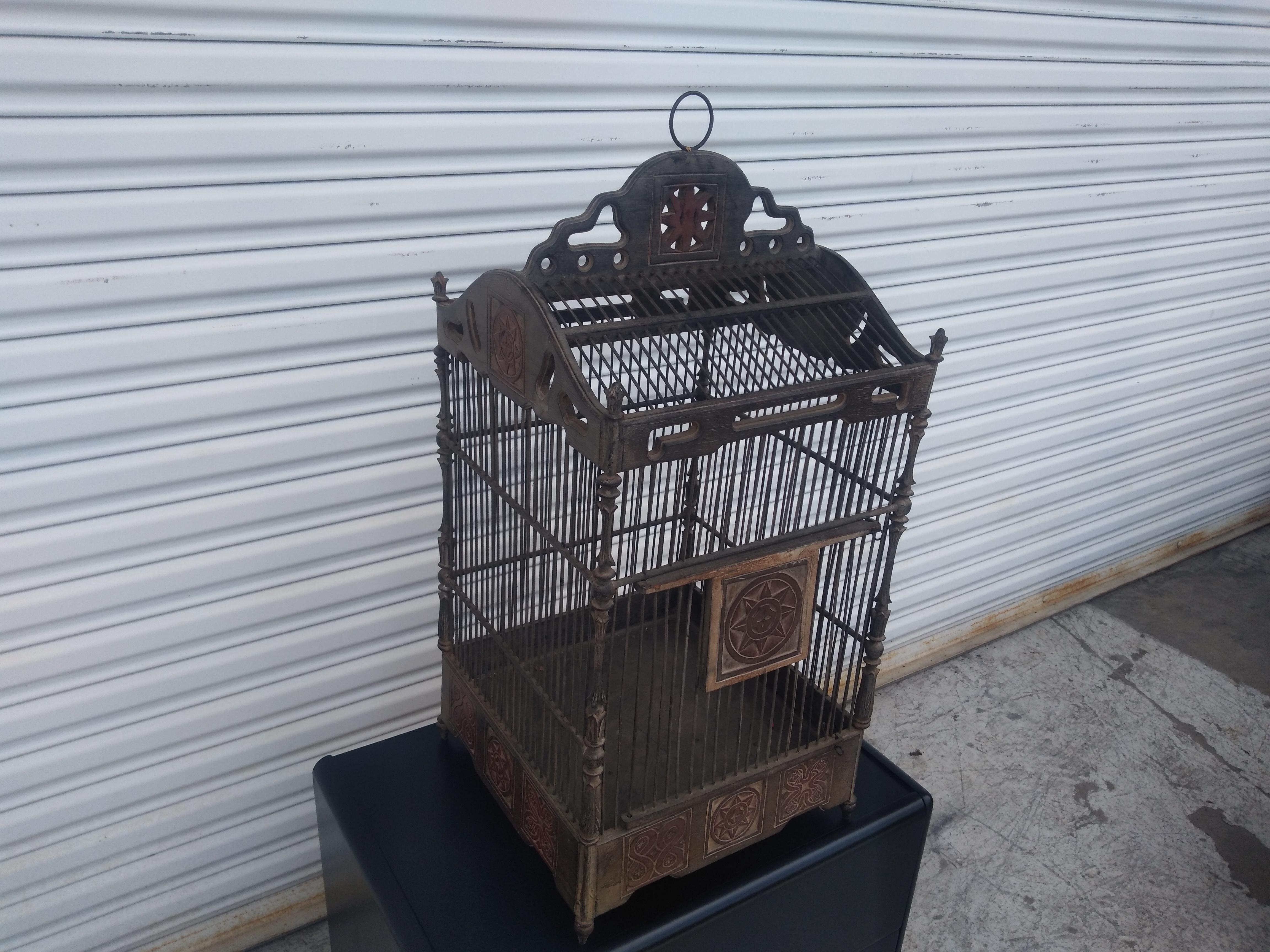 Questo è un  una splendida gabbia per uccelli! È realizzato in metallo e Wood. Ha molte sfaccettature intricate e finemente dettagliate. La porta della gabbia è dettagliata, così come i lati superiori e la parte superiore.