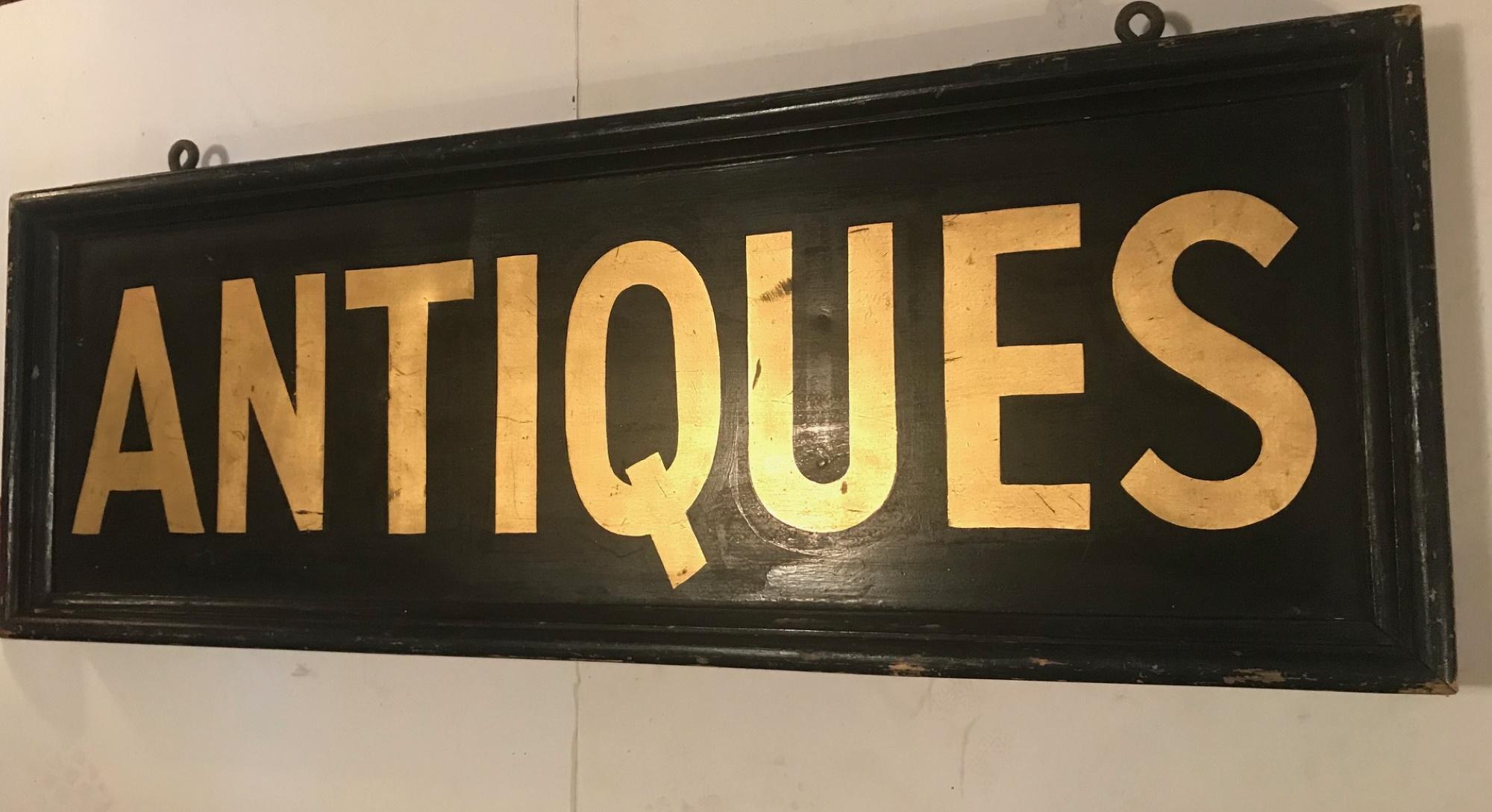 This very rare and vintage sign for the antique trade is from the early 20th century. It is hand painted on metal and the letters are gold leafed on both sides. A solid wood frame and fantastic hardware make an impressive statement.

This sign is