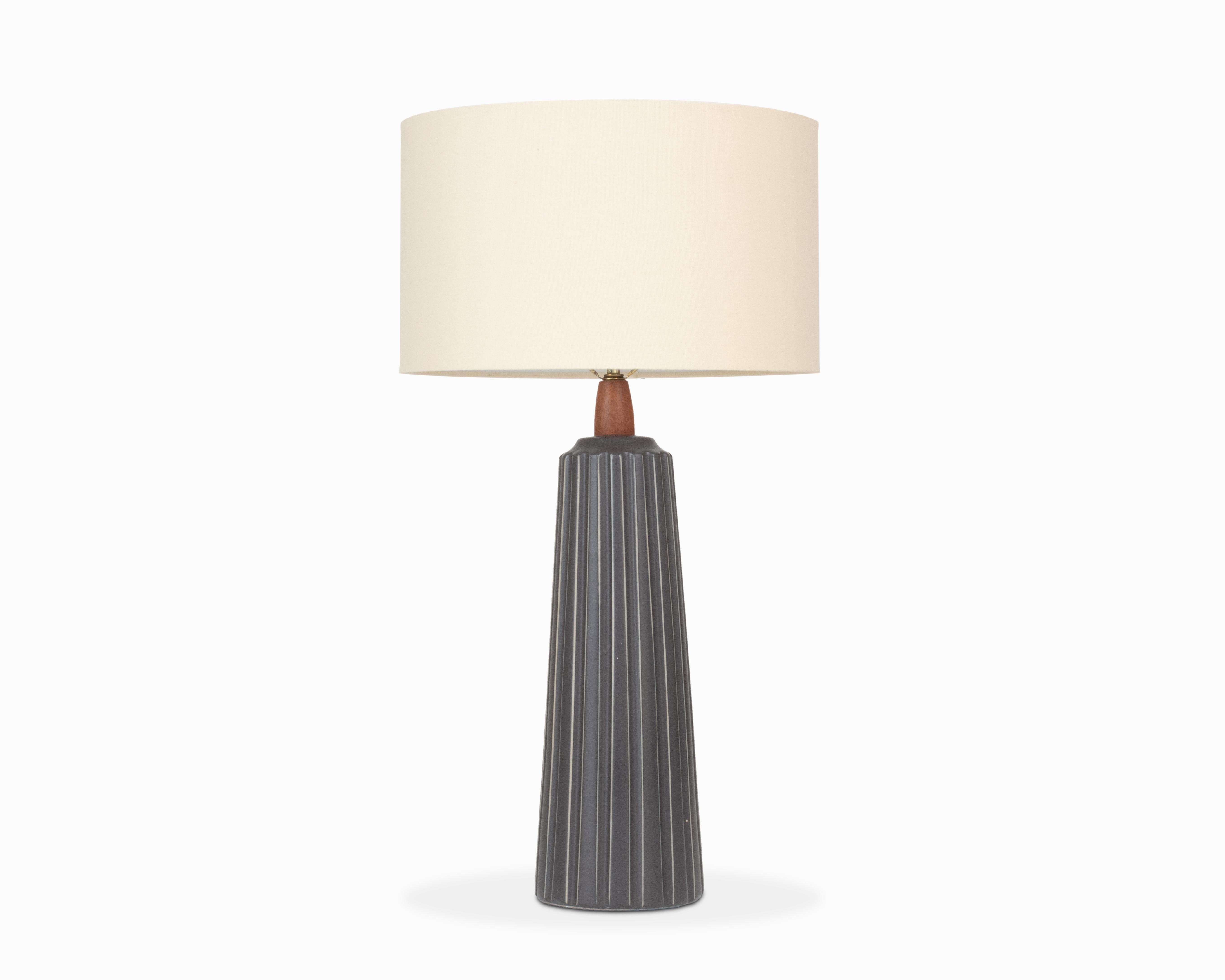 Here is a beautiful ceramic table lamp by Jane and Gordon Martz / Marshall Studios. Model 254 in matte dark grey. It features a monumental fluted ceramic base with vertically striped incising and walnut details. The lamp is in excellent shape with