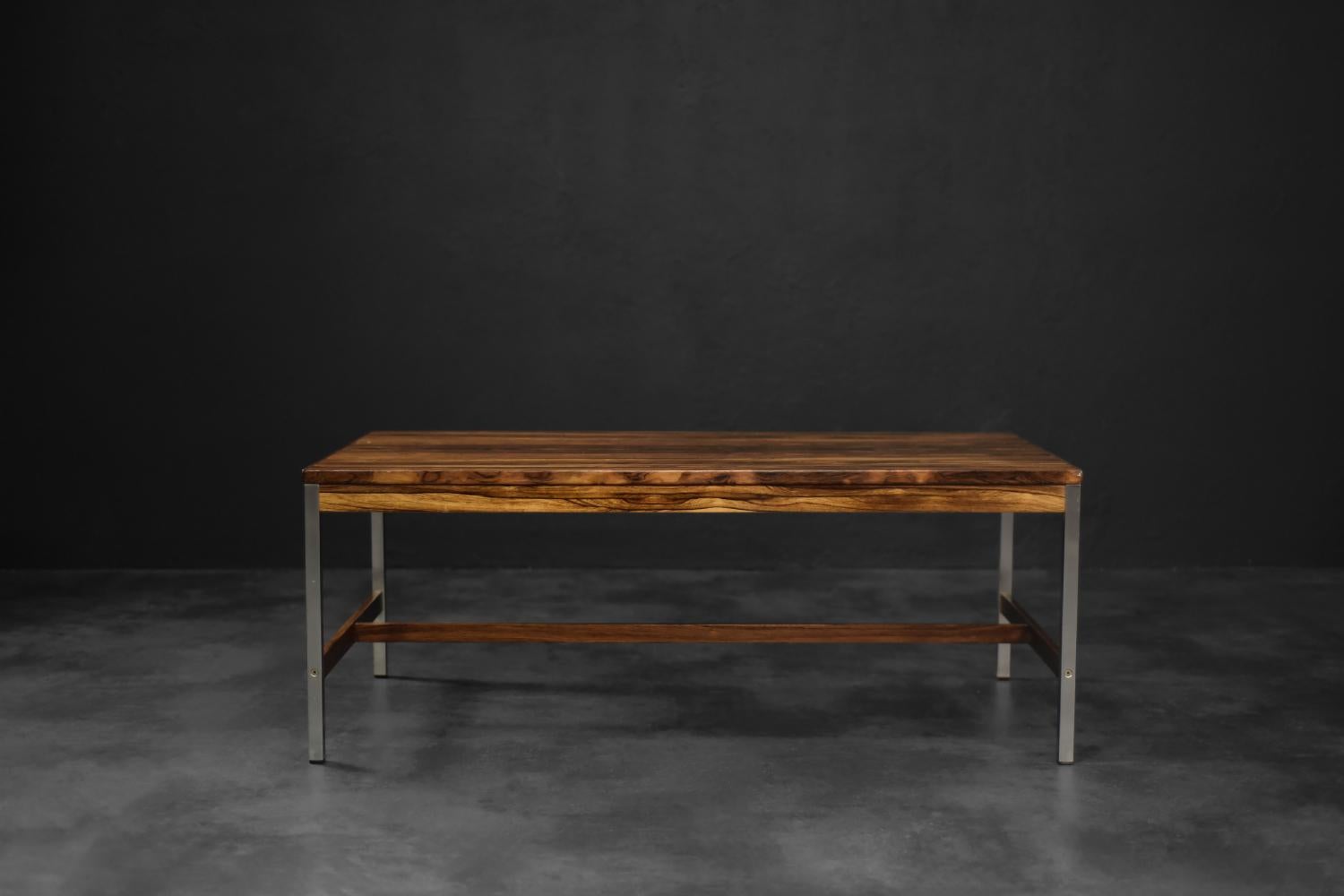 This coffee table was made by the Swedish manufacturer HMB Möbler, in Rörvik during the 1960s. The large, rectangular top is finished with rosewood with a dark, expressive color and strong, hard grain. The rich grain patterns create a very