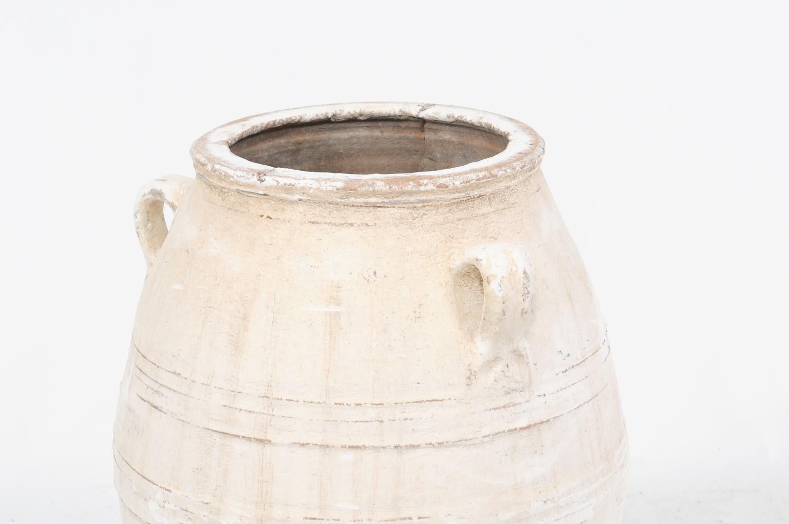 A large vintage three-handled painted terracotta pot from mid-20th century Greece, with white finish and rounded belly. Picture this large 1960s pot in its former life, on a shaded terrace under an olive tree overlooking the Mediterranean Sea in