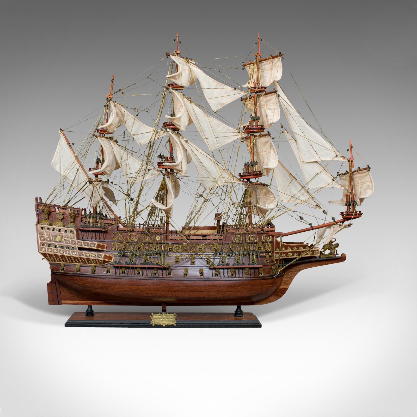This is a large vintage model of the Sovereign of the Seas. An English, mahogany collectible ship on display stand and dating to the 20th century.

Sovereign of the Seas was personally ordered by King Charles I to carry 102 guns, despite being a