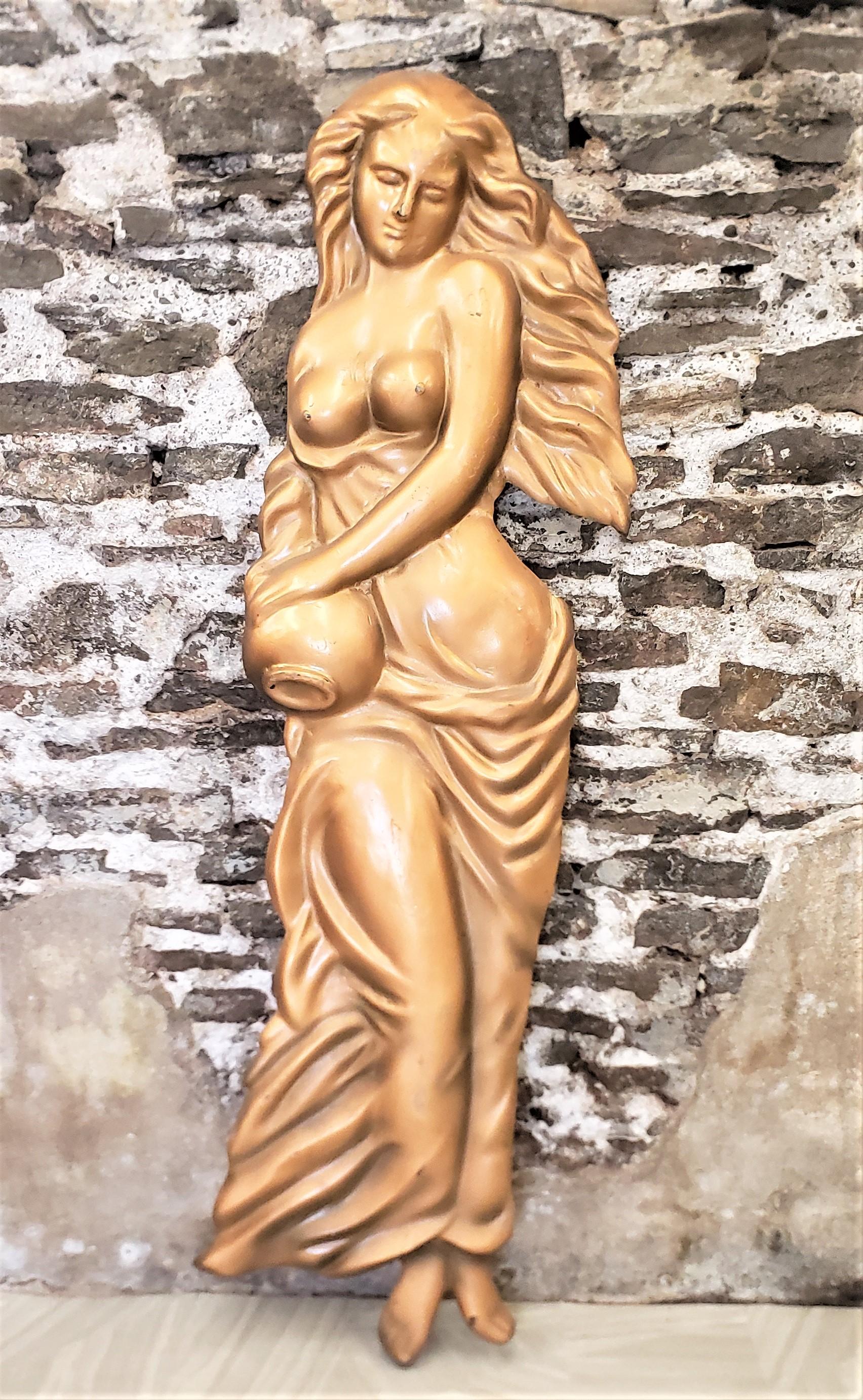 This mid-century era molded fiberglass wall sculpture is unsigned, but presumed to have been made in Canada in approximately 1960 in a Neoclassical Revival style. The relief depicts a seminude young female with long flowing hair and robes carrying a