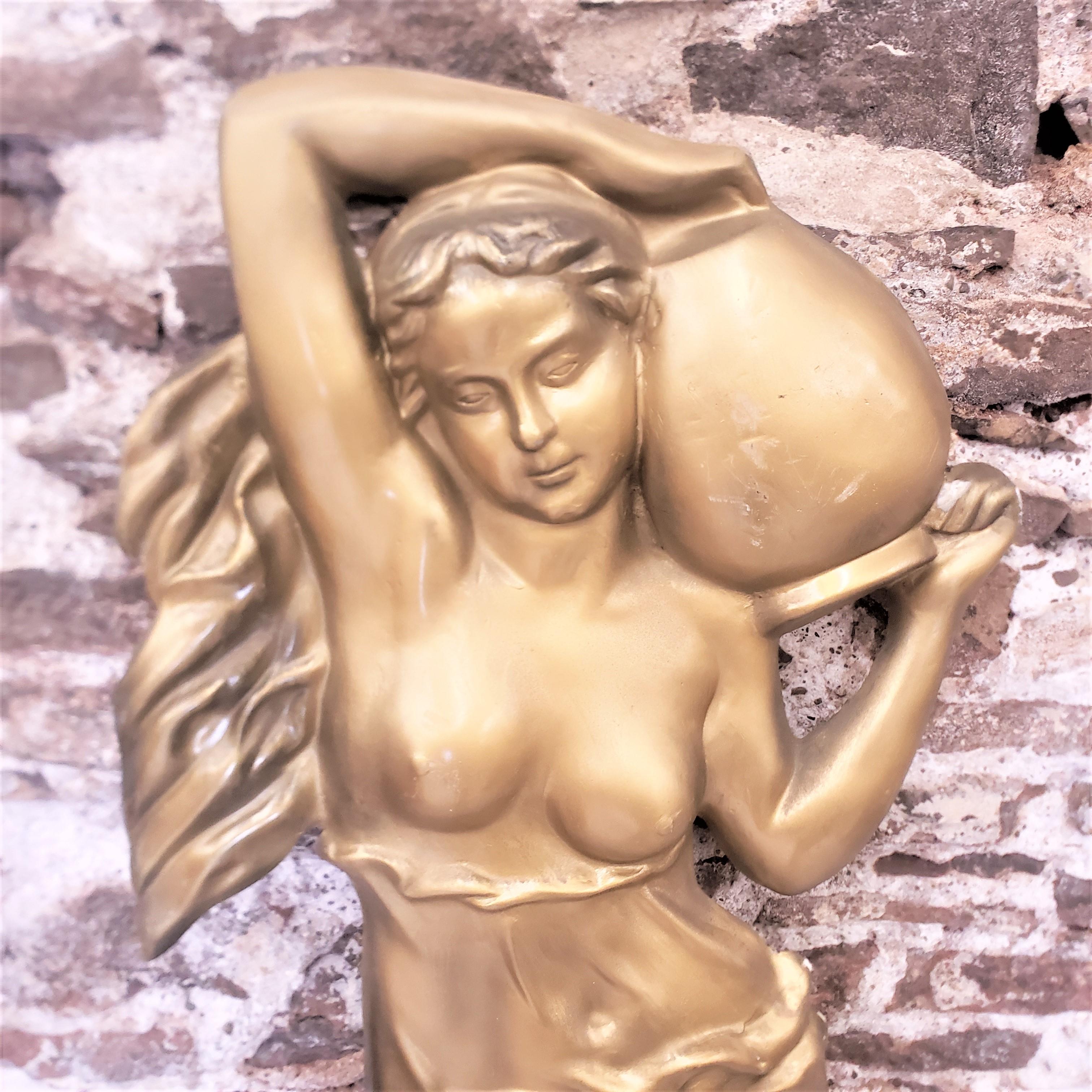 This mid-century era molded fiberglass wall sculpture is unsigned, but presumed to have been made in Canada in approximately 1960 in a Neoclassical Revival style. The relief depicts a seminude young female with long flowing hair and robe, carrying