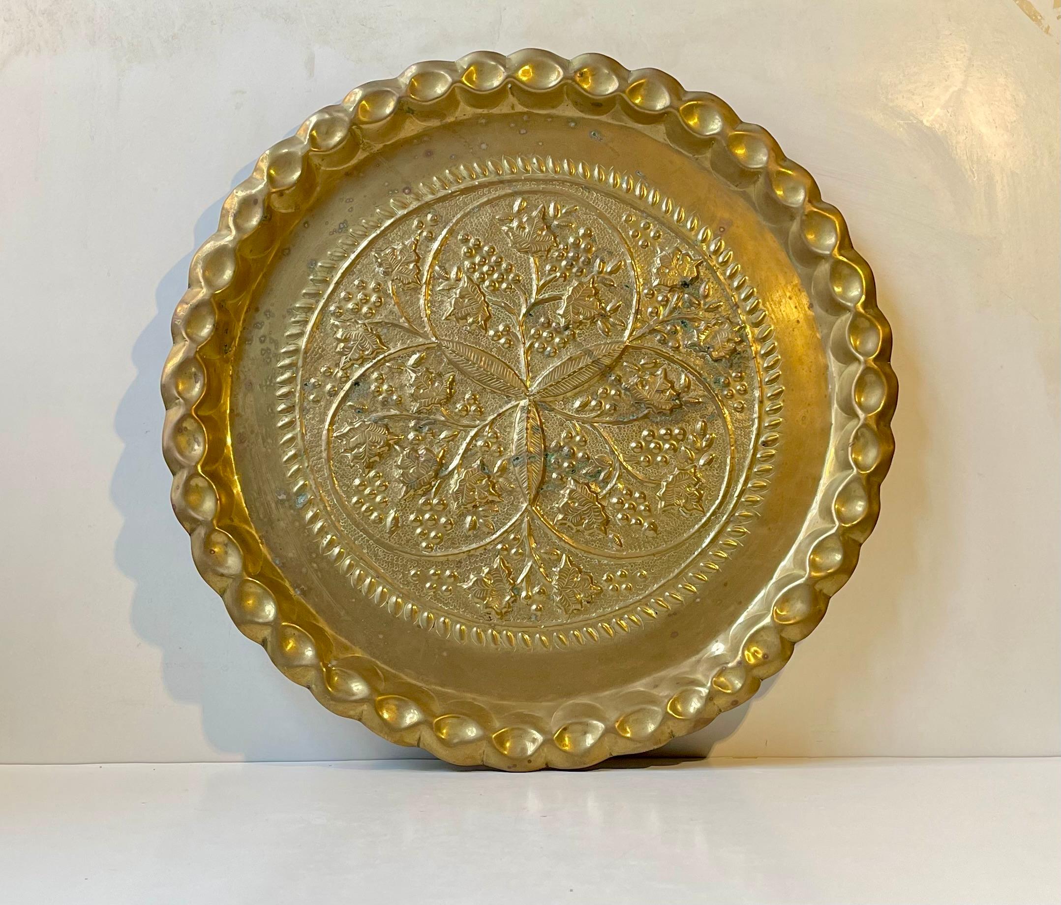 A large (D:46 cm) hand-embossed tray in solid tray. Distinct North African - Moorish styling and ornamentation featuring the characteristic pie-pleaded edge. It was hand-made in Morocco circa 1950s or prior and based upon a much earlier artisan