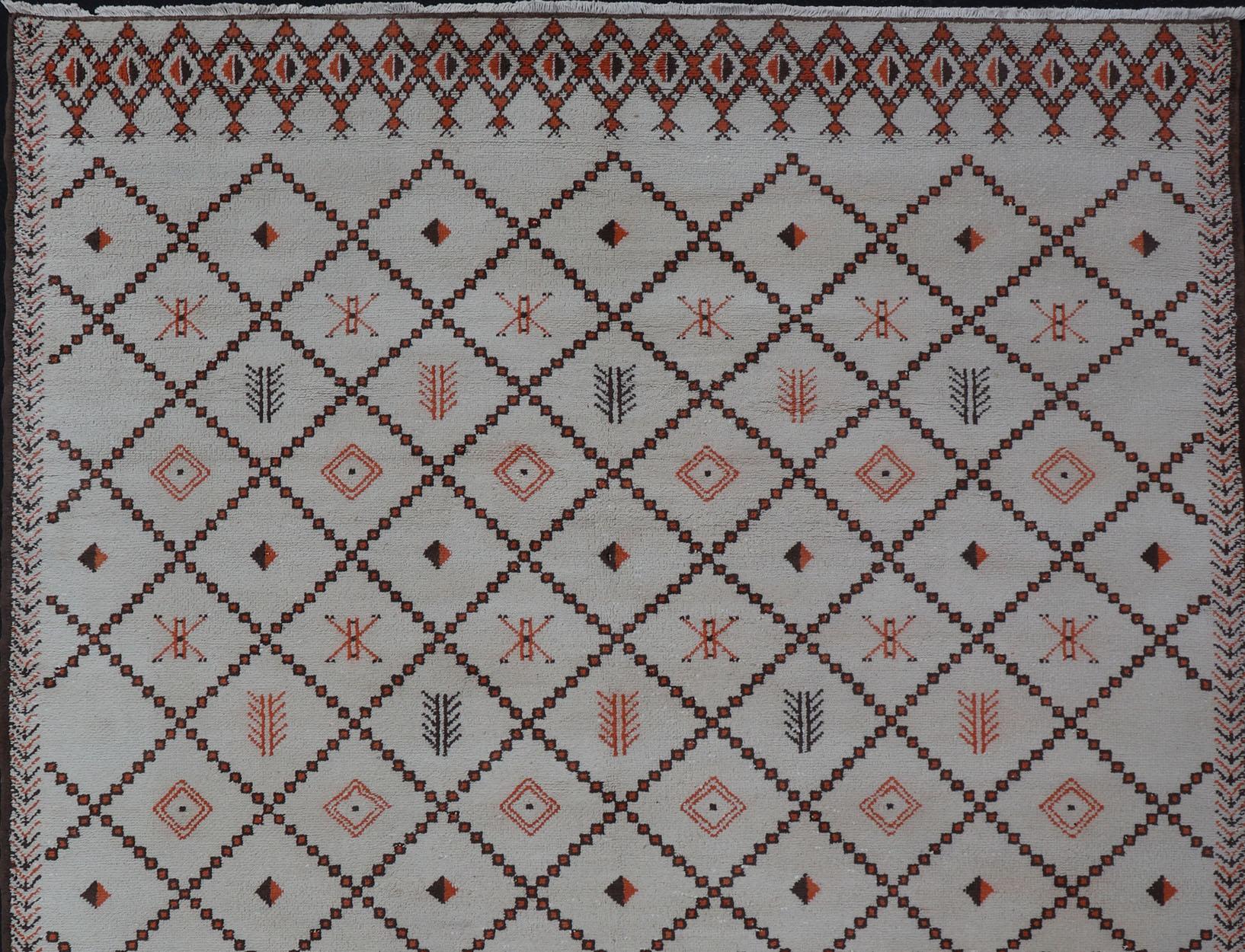 Grand tapis marocain vintage à motifs de diamants avec des contours ivoire et marron. 
Ce tapis marocain est orné d'un motif géométrique en forme de diamant.  sur fond ivoire avec des contours bruns et orange. Les couleurs comprennent l'ivoire,
