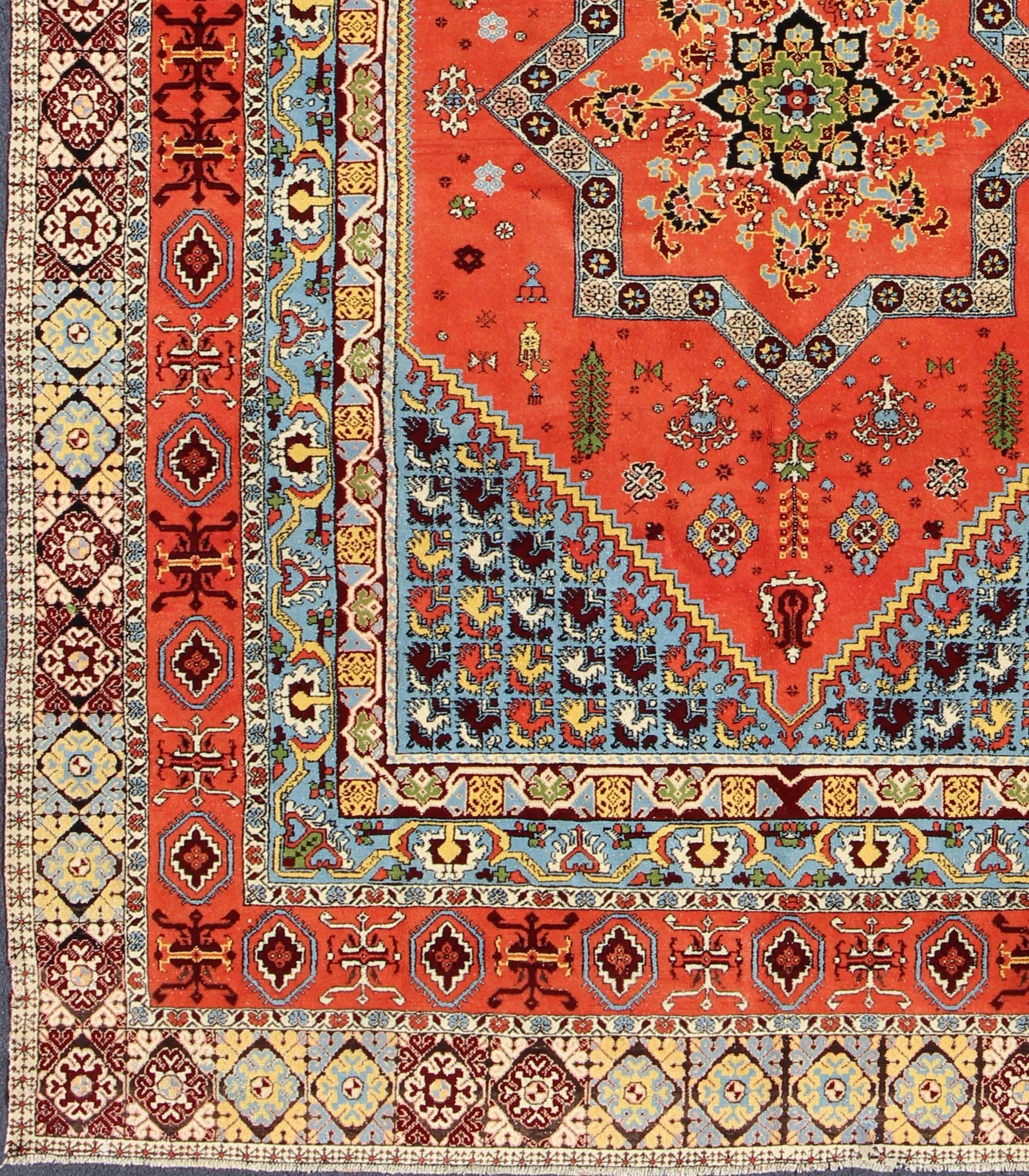 Large vintage Moroccan rug with central medallion design and tribal elements.
This large, vintage Moroccan rug is unique in its central medallion design. A star-shaped medallion is set in the field among various tribal shapes, which extend into the