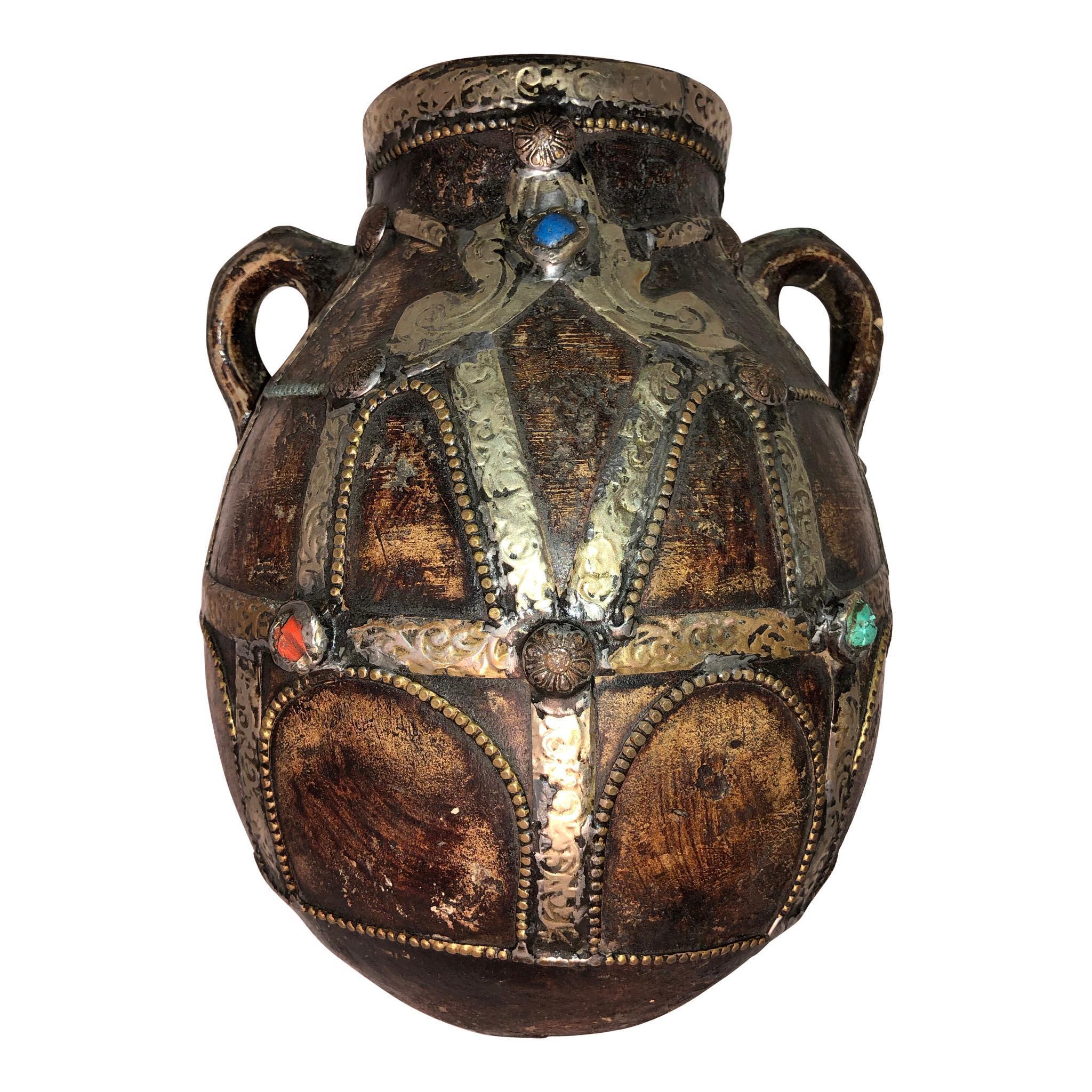 This large Moroccan two-handled jug is heavily decorated in Moroccan silver and copper. Both sides feature a coral bead, a bead of Lapis Lazuli, and a turquoise bead. Made of heavy thick pottery from the Draa Valley of southern Morocco in the early