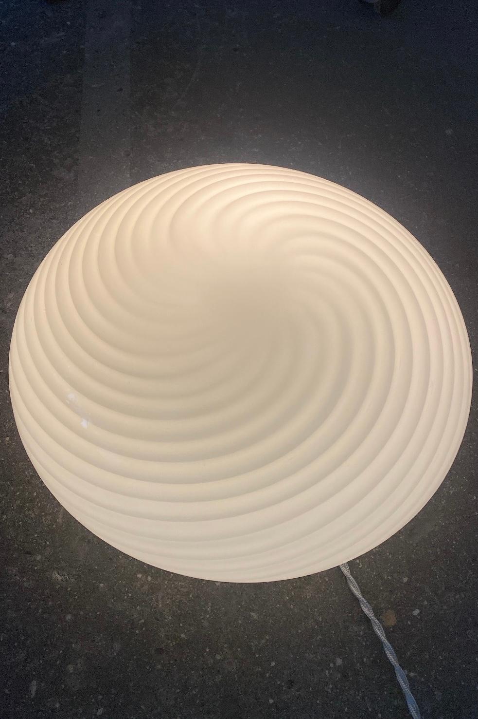 Vintage Murano ceiling lamp. Can be used both as a ceiling lamp and as a wall lamp - Mouth-blown in white opal glass with swirl and comes with a white base. E27 socket. Handmade in Italy, 1970s.

D: 36 cm H: 16 cm.

