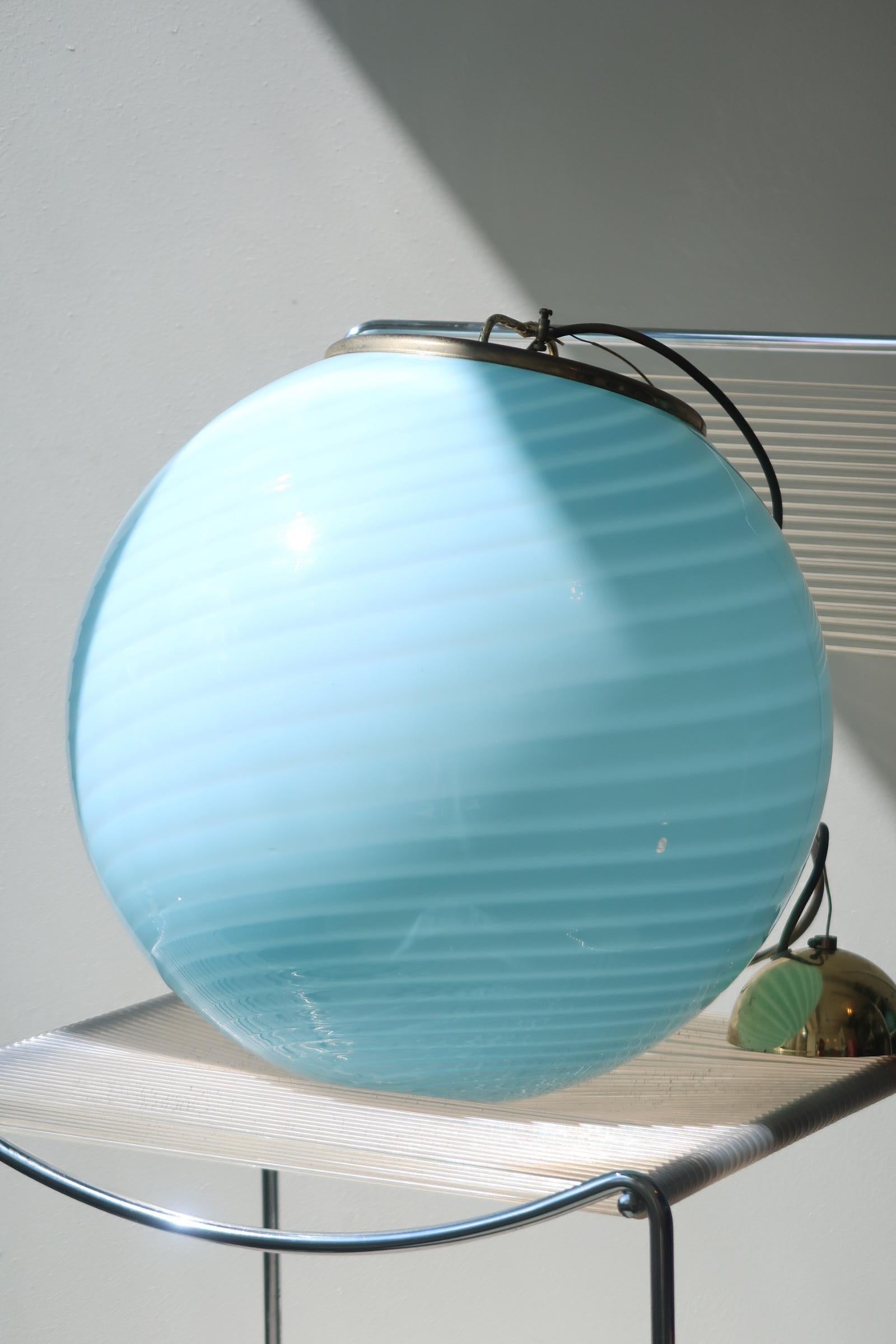 Large vintage Murano Vetri ceiling lamp in light blue glass. The glass is mouth-blown in a round shape with a beautiful swirl pattern. Handmade in Italy, 1970s, and has original Murano Vetri label and brass suspension. Measure: D: 40 cm.
 
