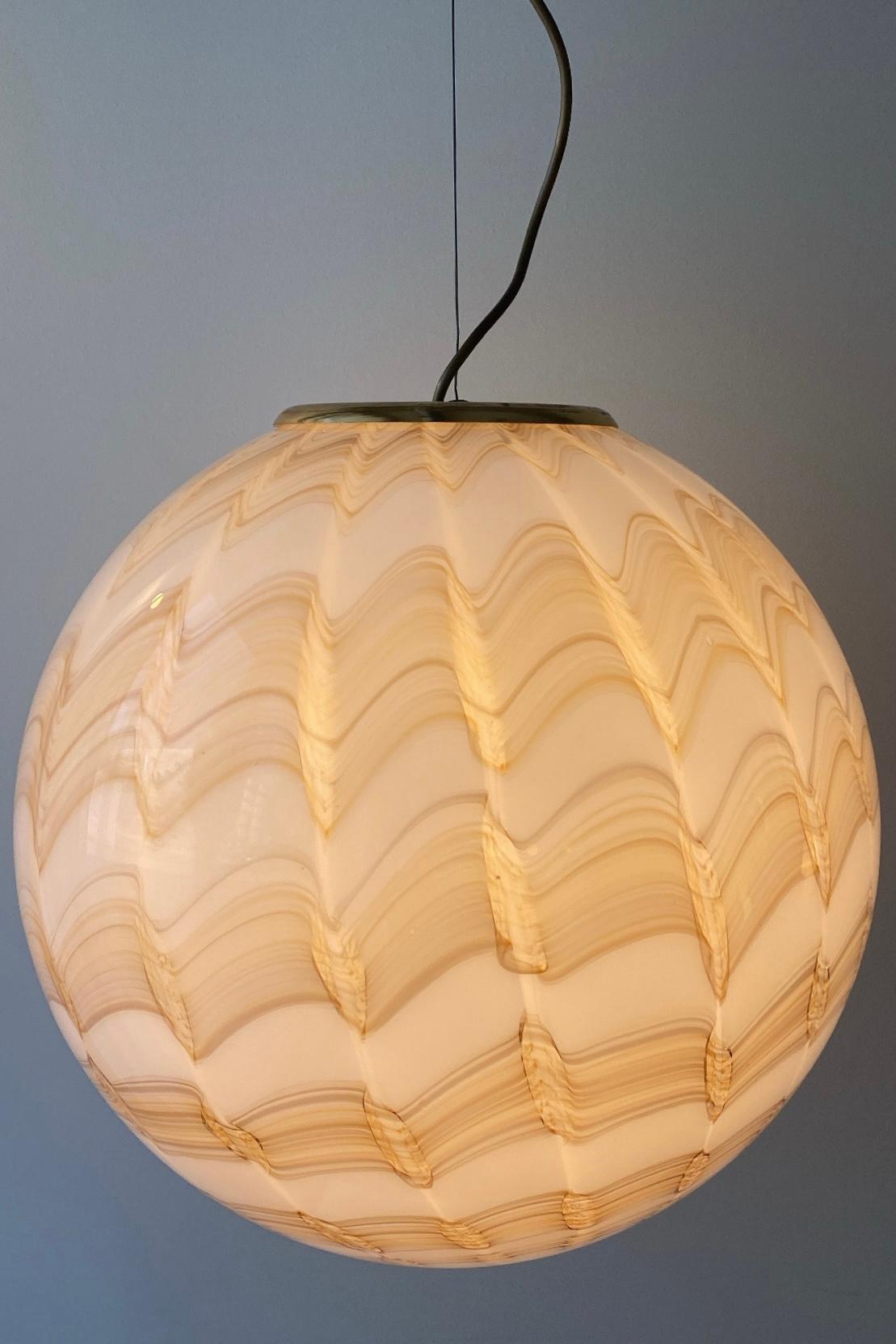 Vintage Murano pendant ceiling lamp. Mouth-blown in white / cream glass with a special pattern and has an adjustable brass suspension. Handmade in Italy, 1970s.
D: 45 cm H: 33 cm.