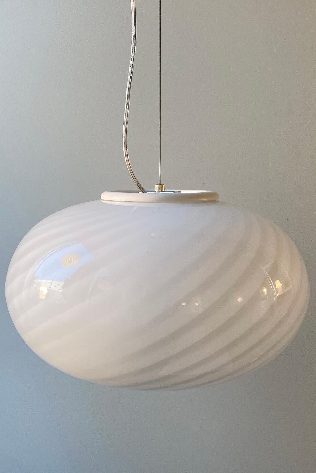 Vintage Murano lampe i hvid glas med en fantastisk smuk swirl. Mundblæst i oval form. Håndlavet i Italien, 1970erne, og kommer med ny transparent ledning.
D:40 cm.

