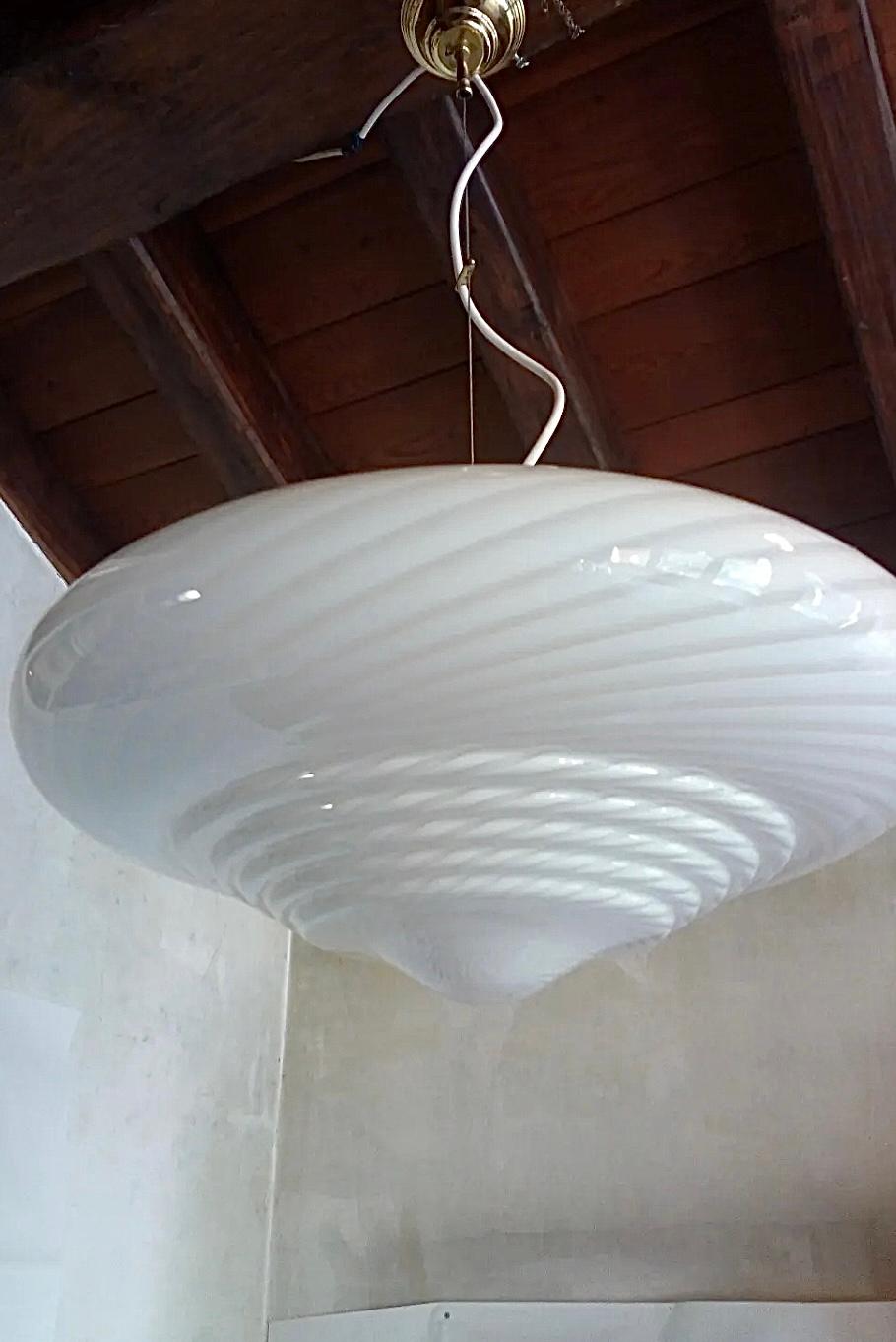 Large vintage Murano pendant ceiling lamp in white opaline glass. The glass is mouth-blown in a special shape with a beautiful swirl pattern. Handcrafted in Italy, 1970s, and comes with adjustable brass plated suspension. 
D: 50 cm 
Glass height: 28