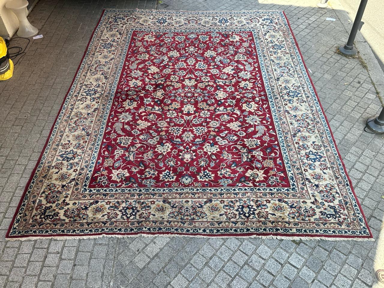 Discover the timeless elegance of this exquisite vintage Najaf Abad rug. Hand-knotted with luxurious wool velvet on a cotton base, its vibrant red backdrop showcases stylized floral and branch motifs in captivating blue, green, orange, and white