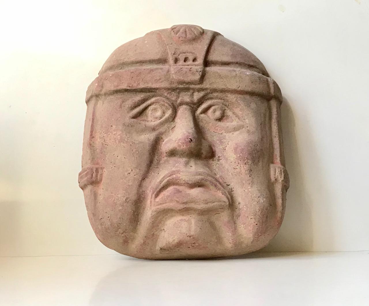 Large (43x36x10 cm) raw terracotta wall mask of an Olmec Warrior. The Olmec's was a pre-culumbian, Mesoamerican civilisation that lived from 1200-400 bc. This particular example is a reproduction dating from the 1970s where it was brought home from