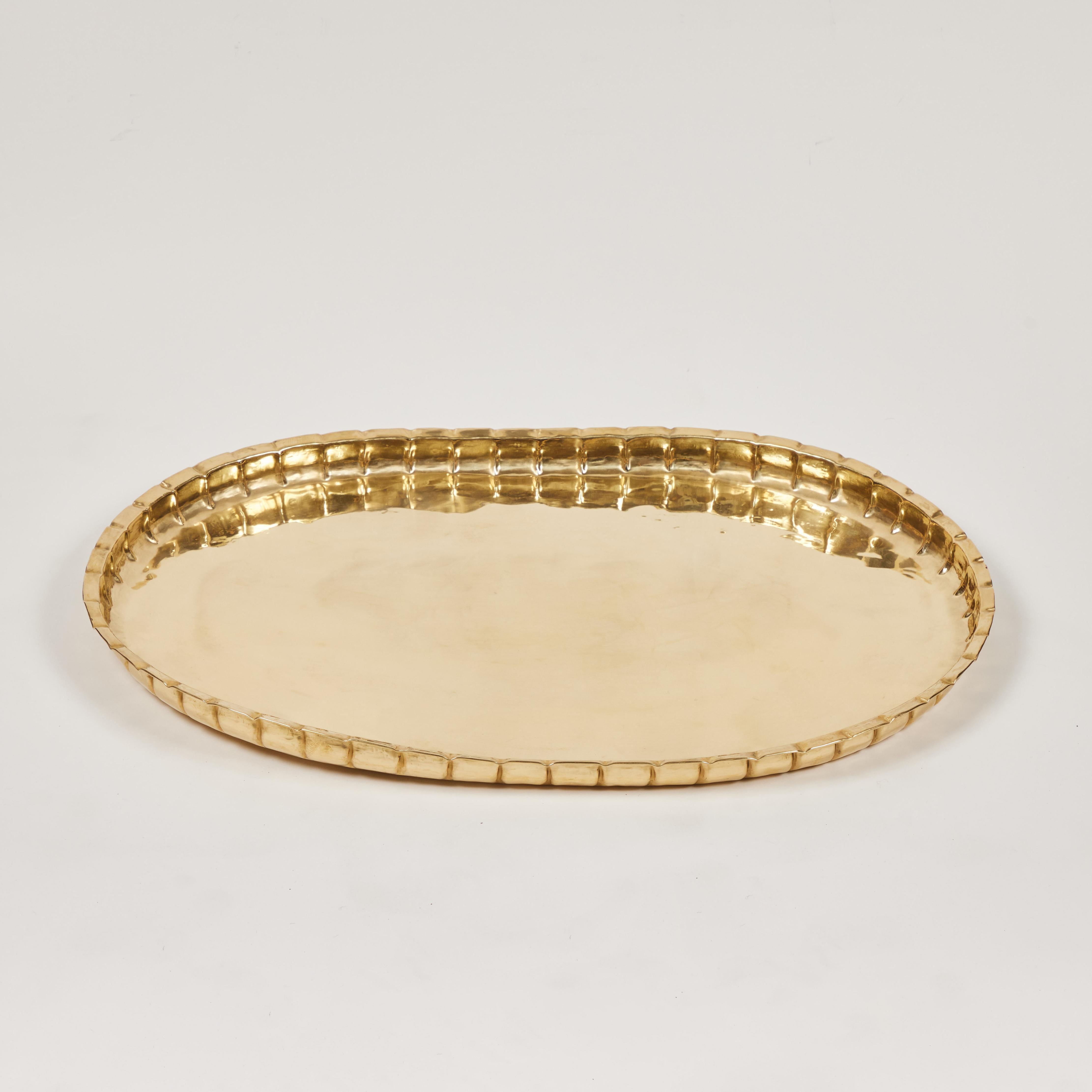 This fantastic large vintage handmade oval brass tray is the perfect addition for a table or ottoman. It is accented with a decorative 'pie crust' crimped edge surround and has been newly polished. 

It measures 28