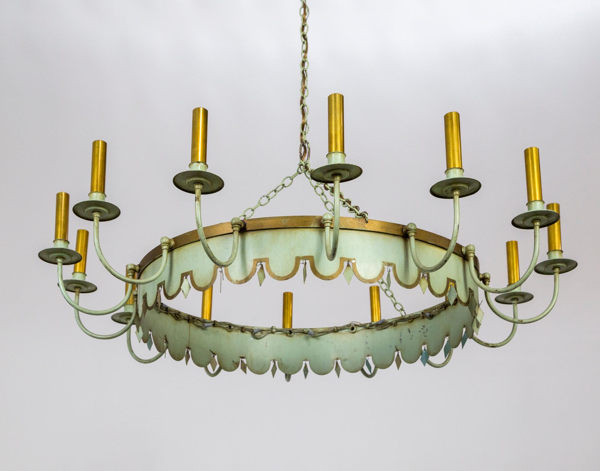 A large, French, ring-shaped, lacquered metal chandelier in a versatile, pale green hue with gold trim, made in the 1940s; with small, matching metal, diamond pieces hanging between scallops on the bottom edge, and 14 candlestick lights on delicate,