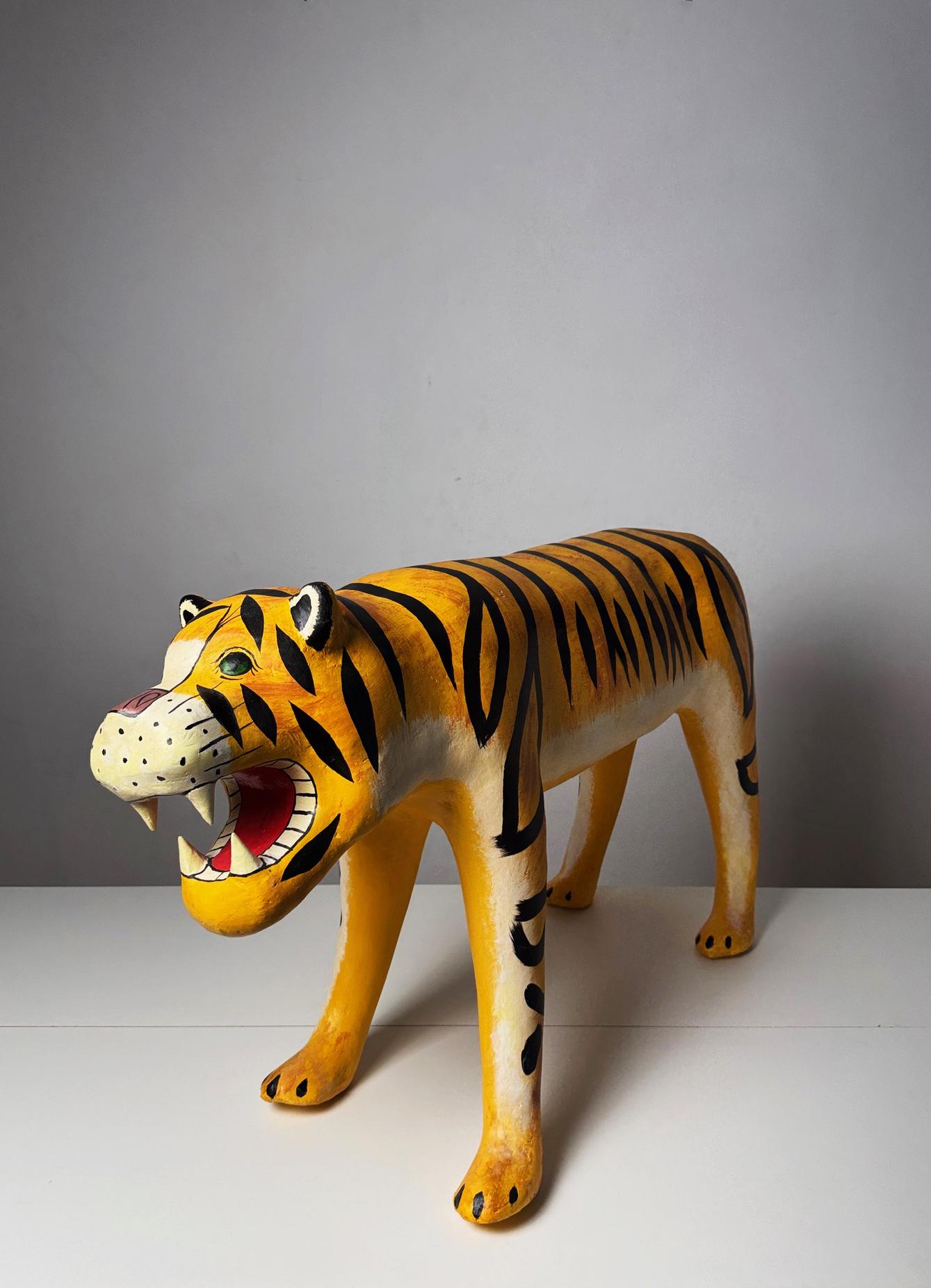 A striking and whimsical large vintage papier-mâché tiger sculpture, crafted circa 1970s in a bold folk art style. This expressive piece features a dynamic stance, hand-painted stripes, and an open-mouthed grin that adds personality and a touch of