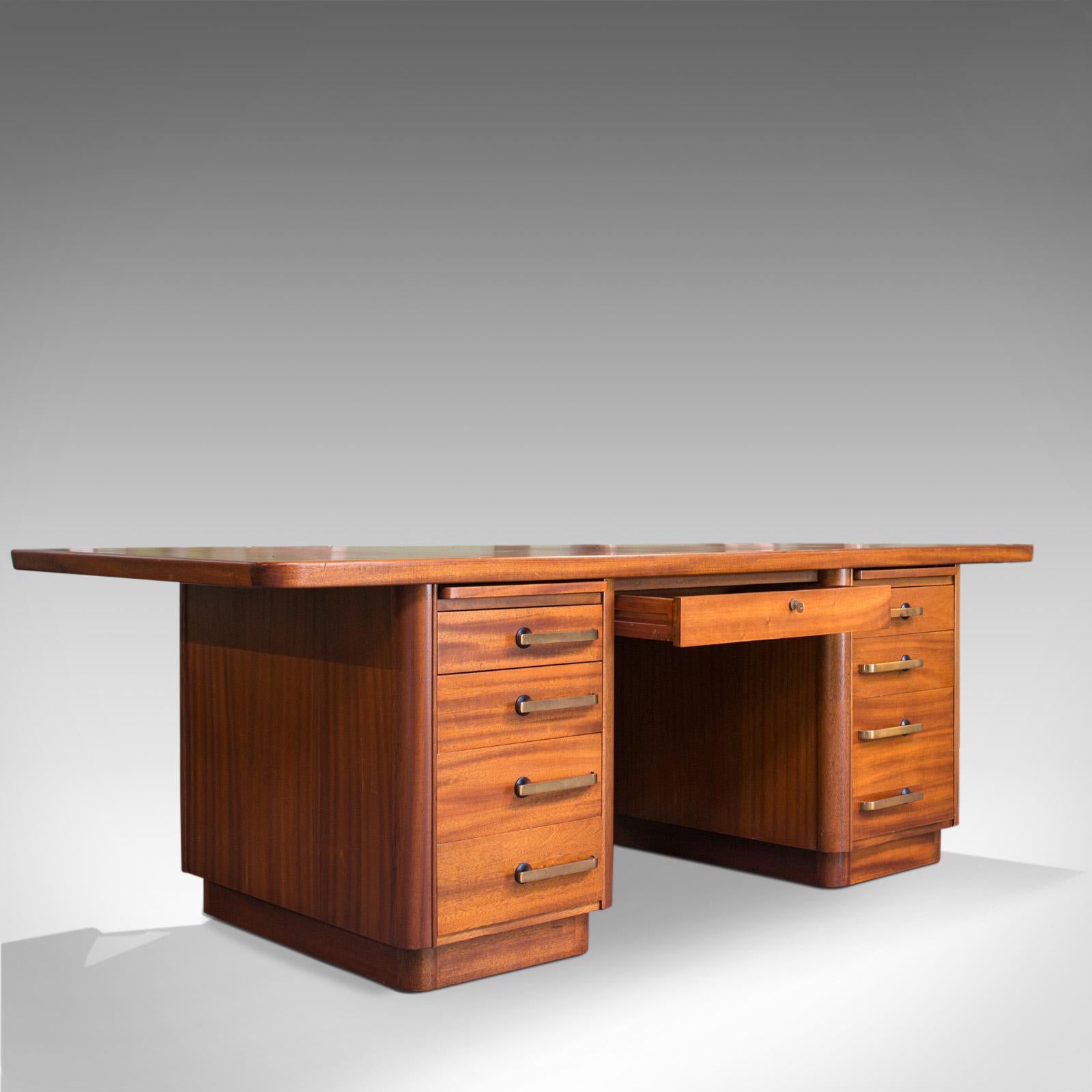 This is a large vintage pedestal desk. An English, teak and leather office desk by the sought after cabinet maker, Abbess, with strong Art Deco overtones and dating to the mid-20th century, circa 1950.

Attractive teak desk with good consistent