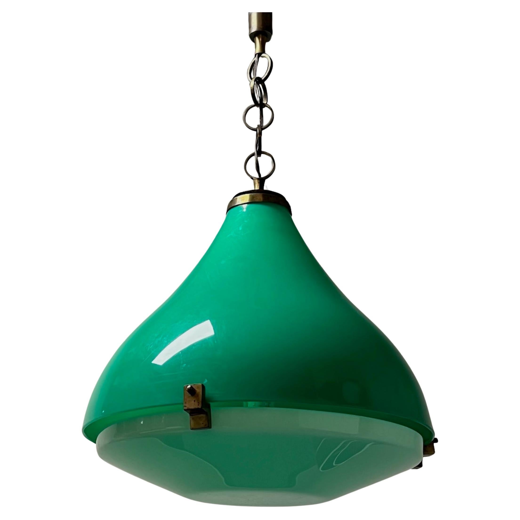 Una bellissima e maestosa lampada a sospensione realizzata negli anni '60 con un grande paralume in plastica verde smeraldo e dettagli in ottone e metallo. Grazie alle sue grandi dimensioni, questa lampada è un complemento perfetto per grandi stanze