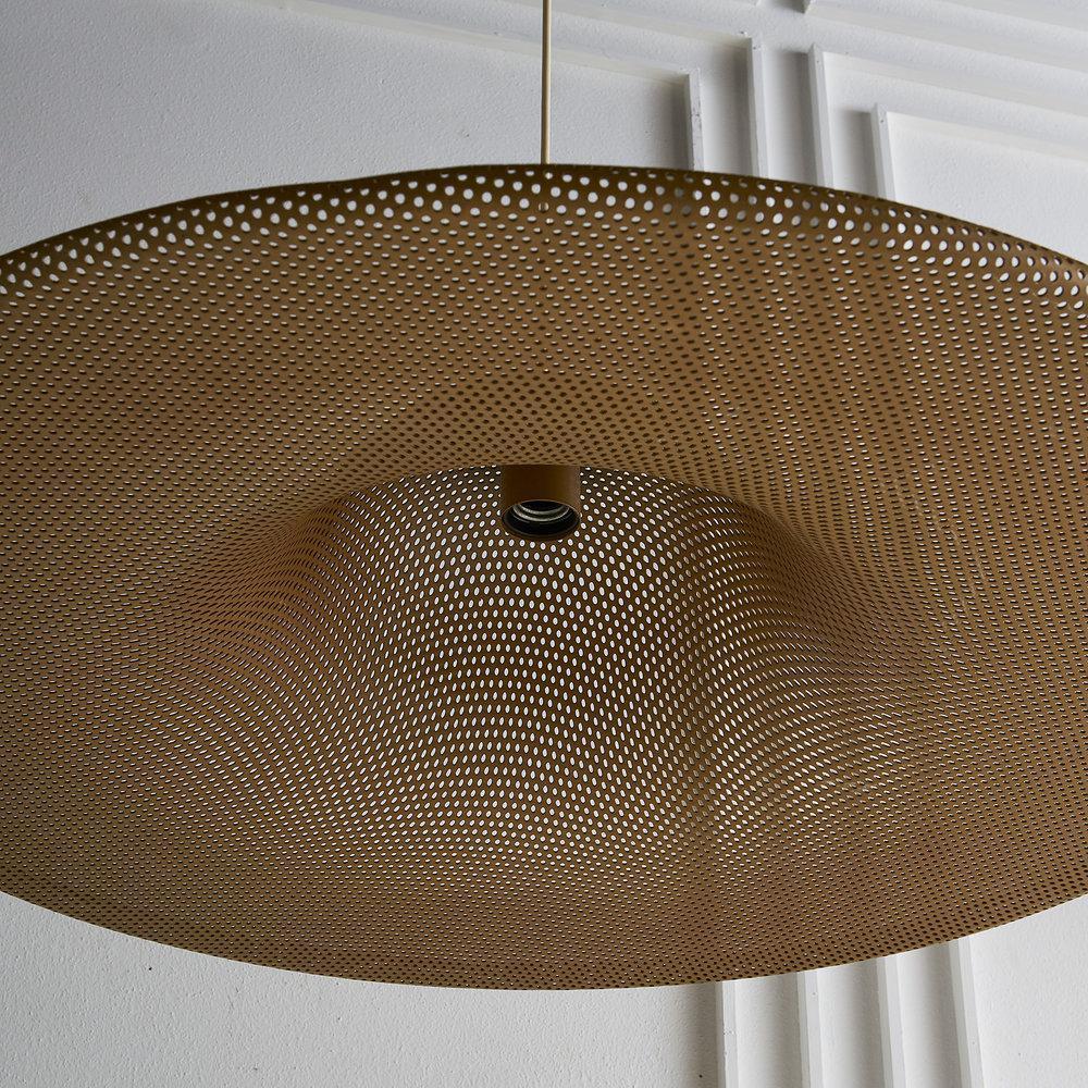 A large European perforated brass pendant light we sourced in France. The pendant light is made of perforated metal with a deep gold finish. The maker is unknown and there is no marking. The pendant was new wiring for US use and accepts a standard