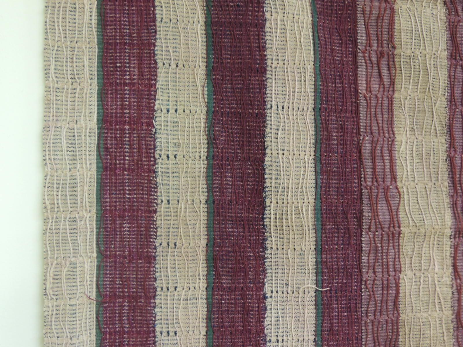 Large vintage purple and brown Yoruba Stripe African Textile.
The Yoruba are highly fashion-conscious people. Colors change from season to season and such non-traditional fibers as Lurex can be introduced into strip woven cloth. A common form of