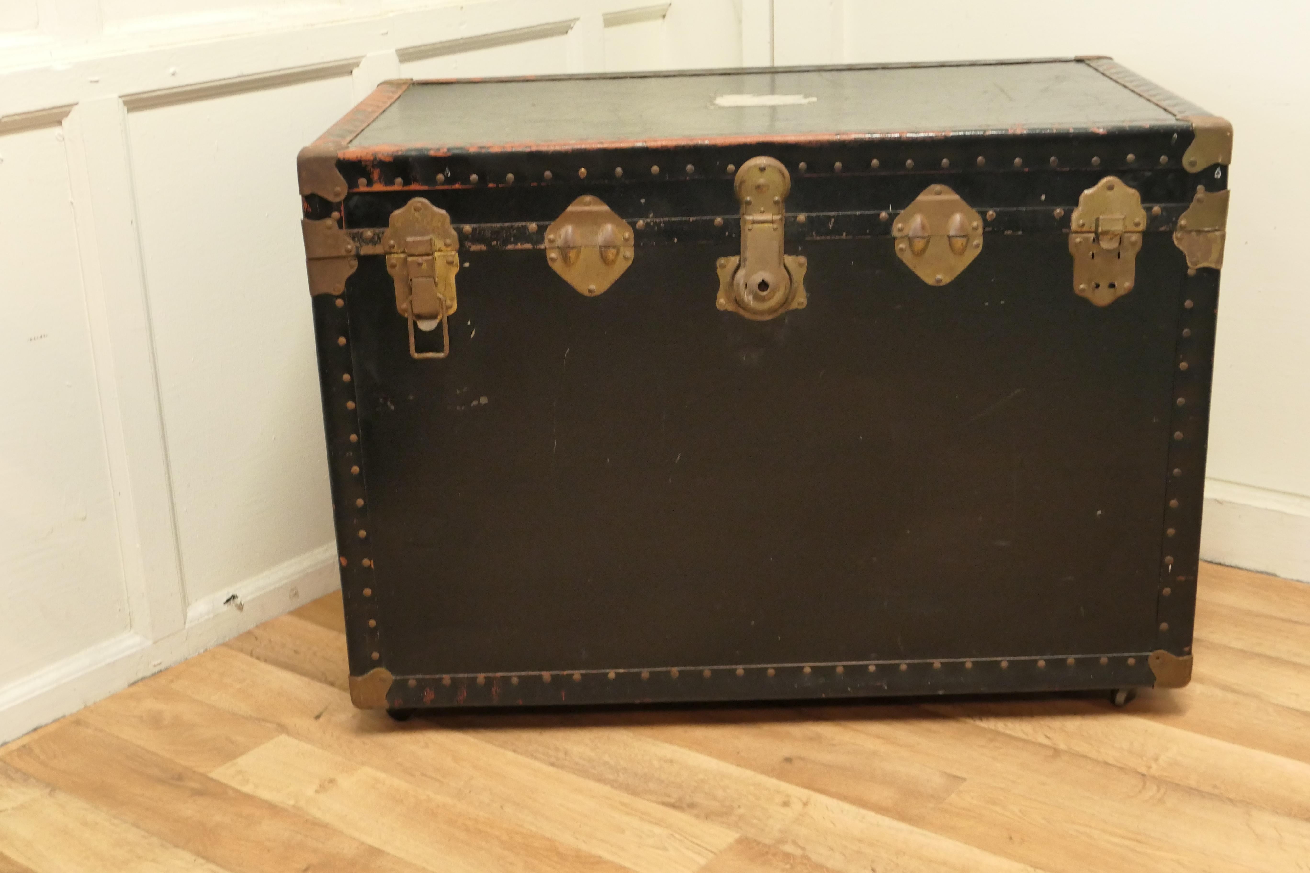 Large vintage rigid canvas travel trunk, steamer trunk on wheels.

A very useful decorative travel trunk, it is lined in linen fabric, it has one leather carrying handles, and one stronger metal handle.
The Trunk is canvas covered, with metal