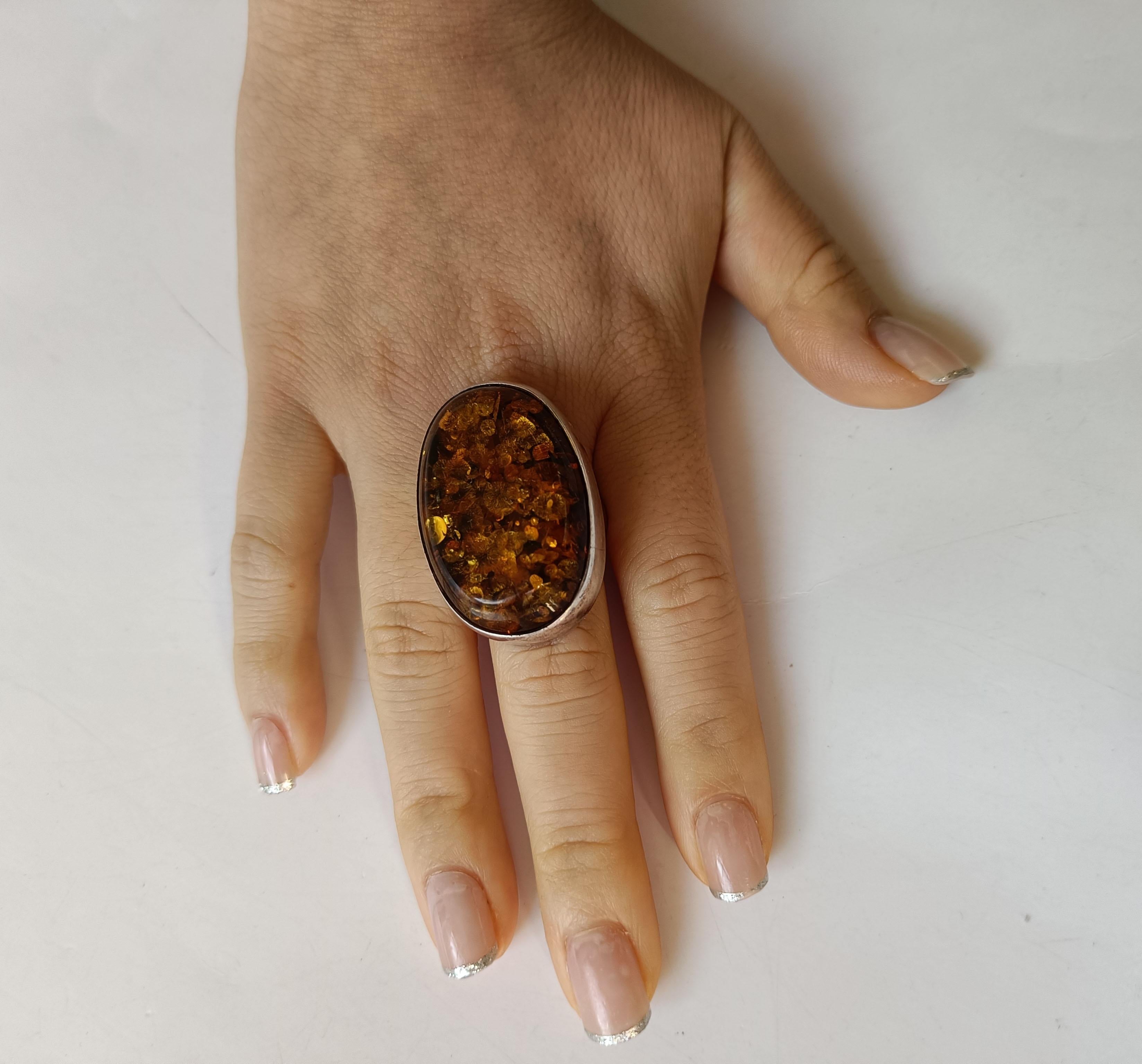 A fine vintage handcrafted Silver Baltic amber  ring
A particularly fine  ring with a large Baltic amber cabochon with crystalized deposits
Period 1970 s Marked 925
Measures: 1 1/2 x 1 inches.    4 x 3 cm   Size US.. 8.5 .   
 