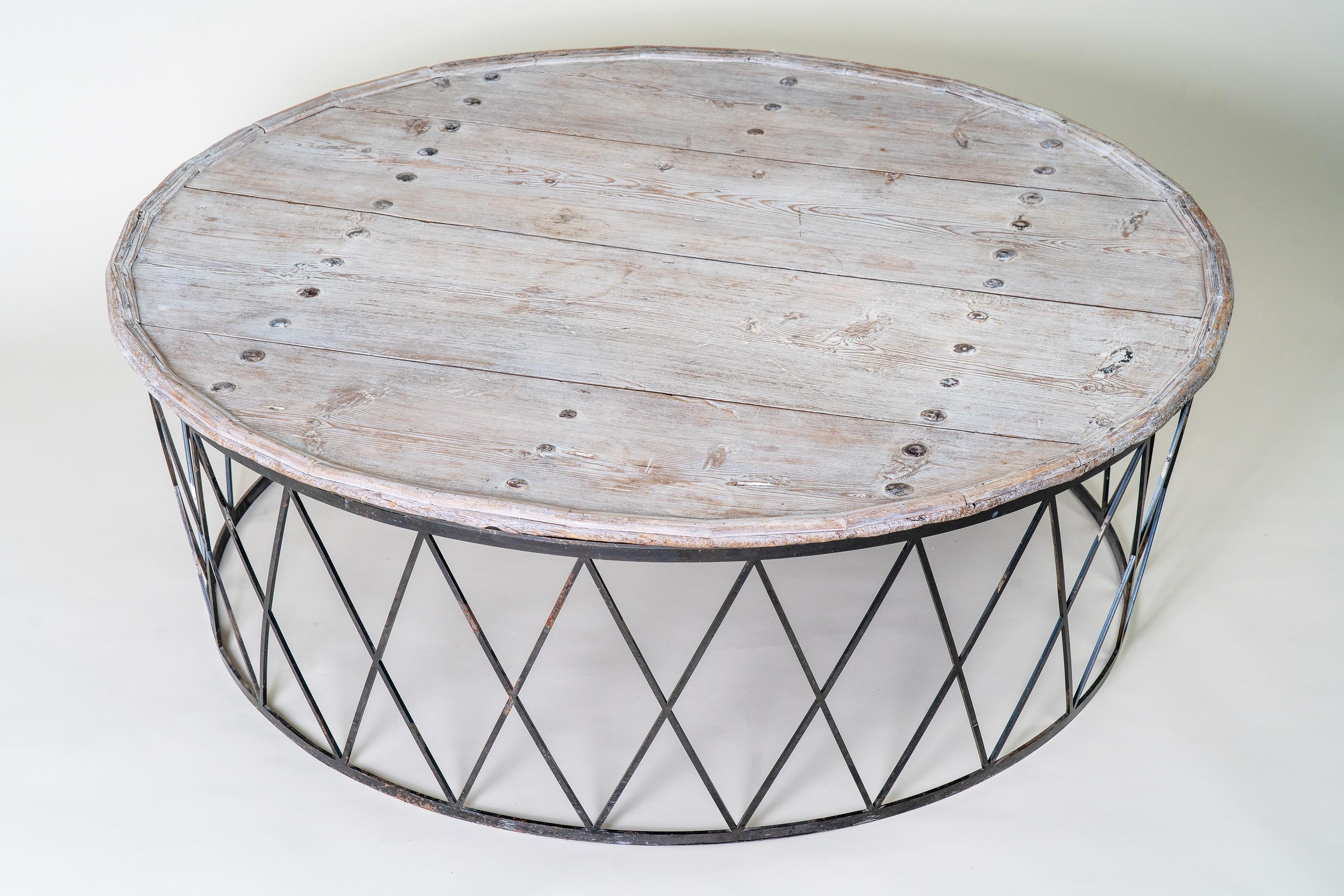 Cette table basse ronde combine le charme rustique avec un bord industriel, créant une pièce maîtresse polyvalente pour une variété de styles d'intérieur. Le plateau de la table est fabriqué à partir de planches de bois récupérées et patinées par