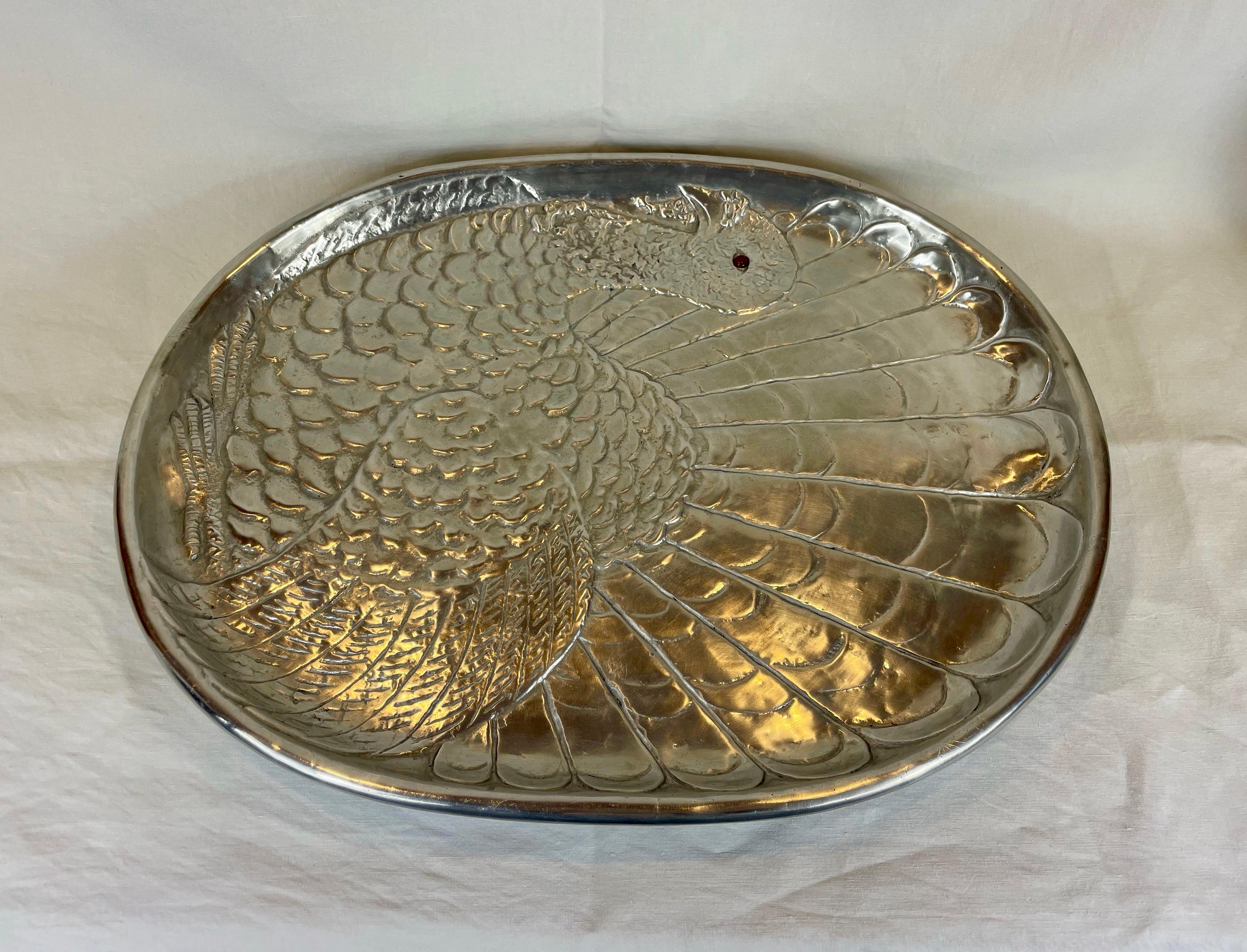 Large polished aluminium serving platter by Arthur Court.
This striking platter is entirely decorated with a wonderful turkey design and has a red carnelian eye.
Supported on 4 sculpted turkey feet and signed Arthur Court 1987.