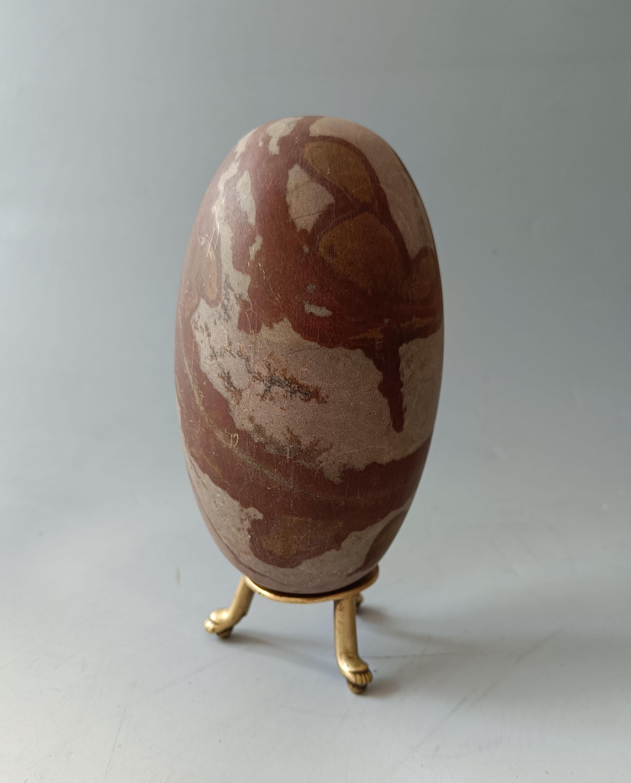  
 
A  multi-coloured stone Shiva Lingam, a  elongated egg shaped stone used for Shaivite worship in Hindu rituals These heavy stones are sacred and come from the Narmada River in India and a collected and polished for use in temple rituals. They