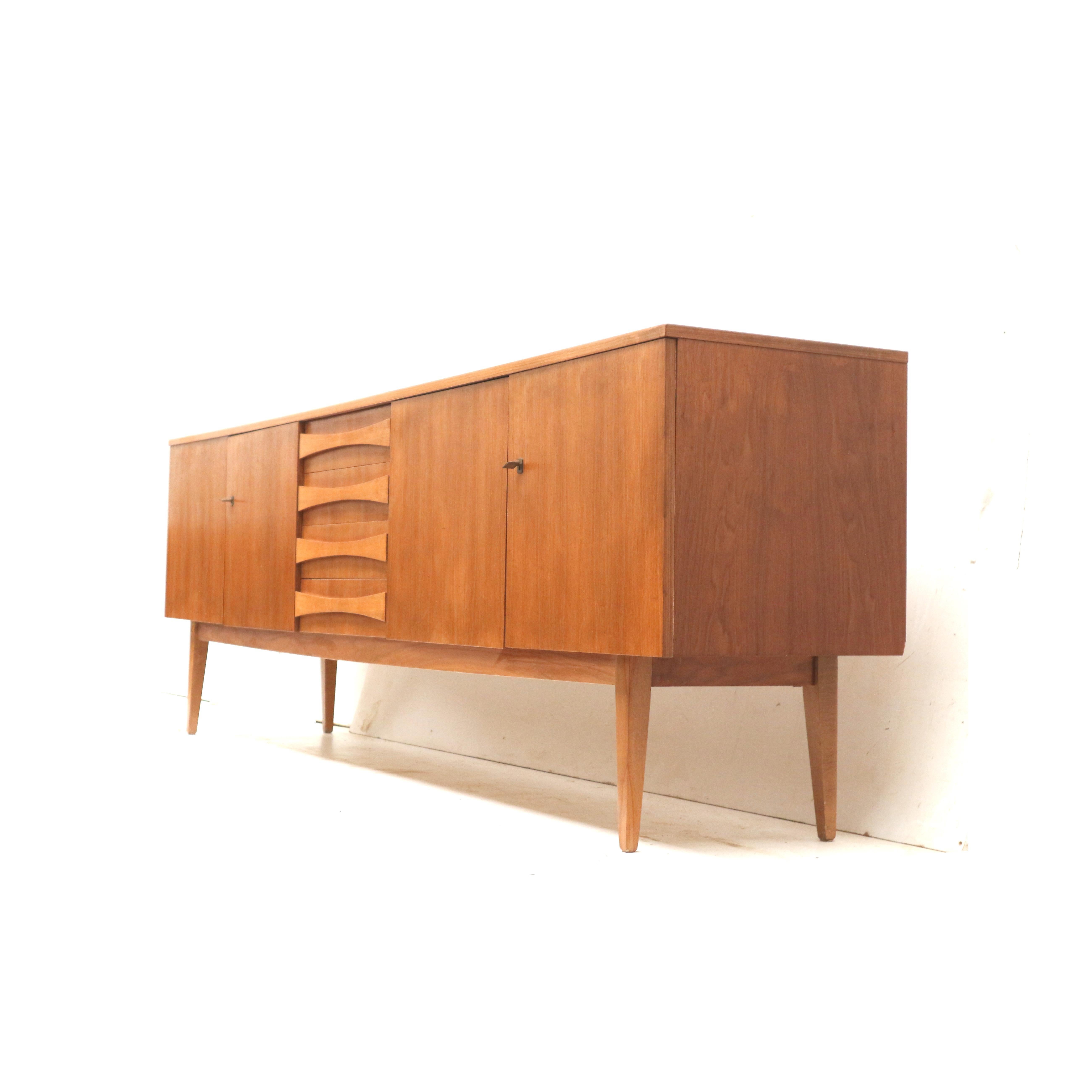 Großes Vintage-Sideboard aus den 60er Jahren.

Abmessungen:
Breite: 250,3 cm
Tiefe: 48,4 cm
Höhe: 81 cm

Die Anrichte weist altersgemäße, leichte Gebrauchsspuren auf.