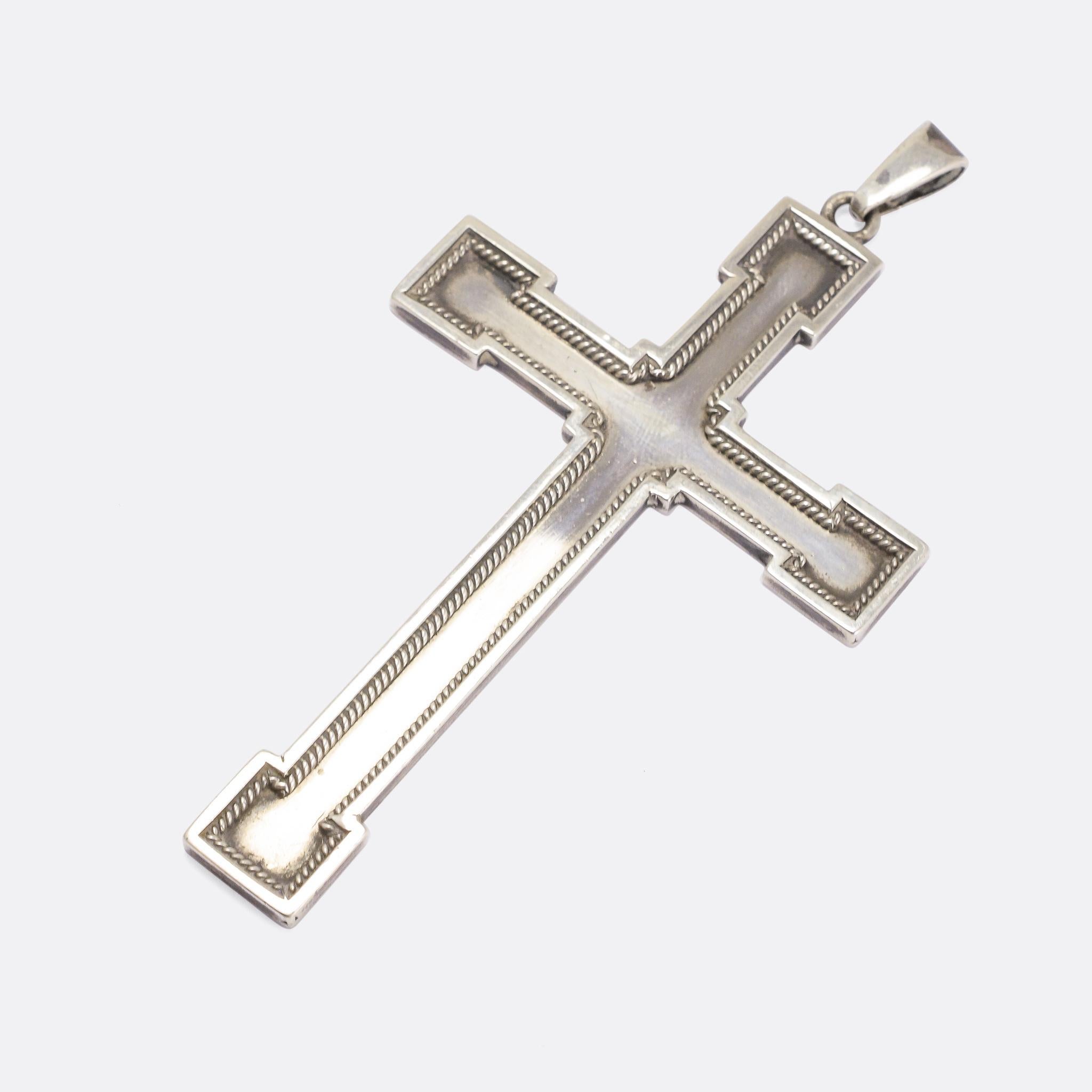 A large silver cross pendant with applied ropework adornment around the outer border. It's crafted in sterling silver, and dates from the year 1945 - with the date July 25th inscribed on the back. A great statement piece that's developed a beautiful