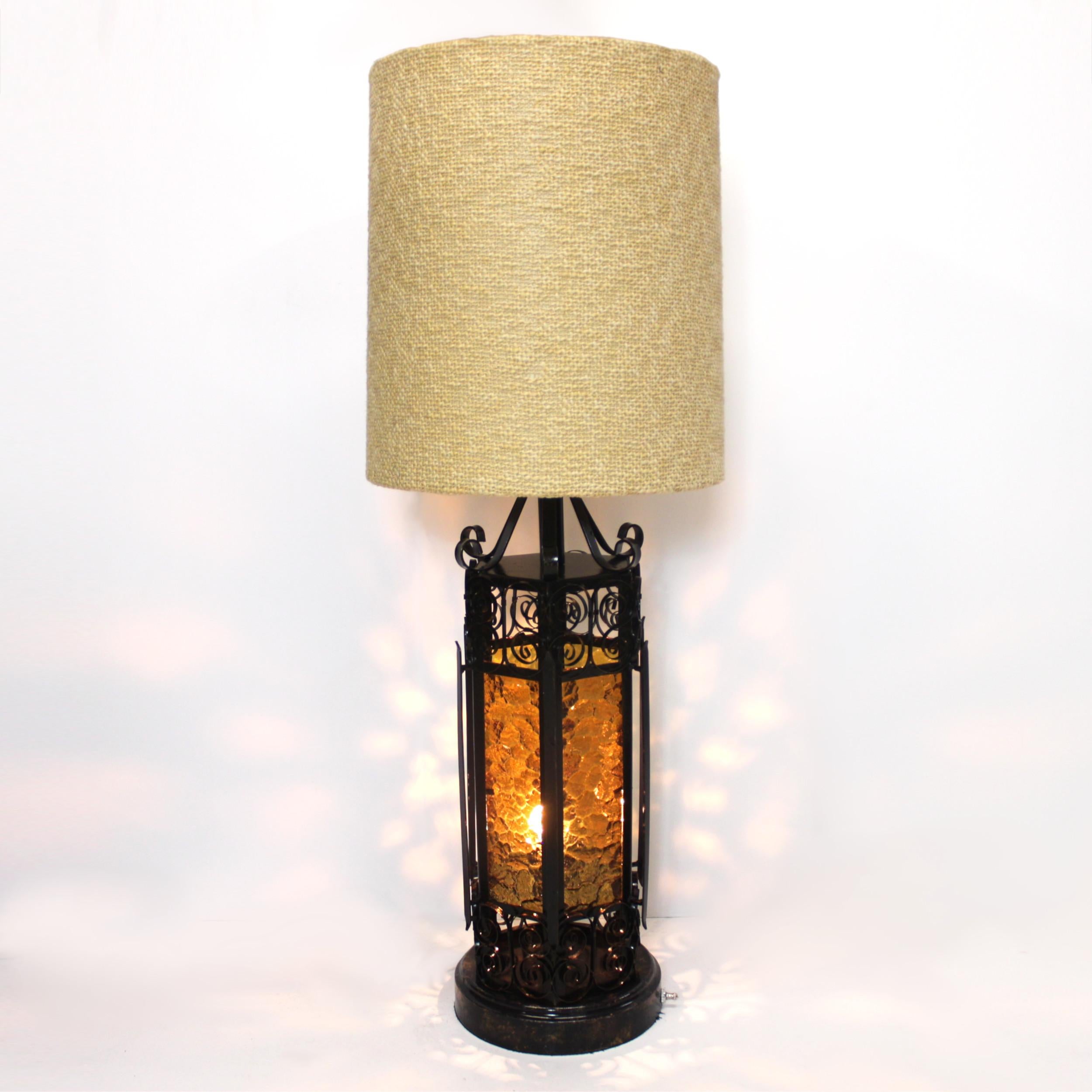 This wonderful Spanish/Mediterranean, Gothic-Revival style table lamp features an ornate wrought-steel base with amber-colored stained glass inserts. A large, 18