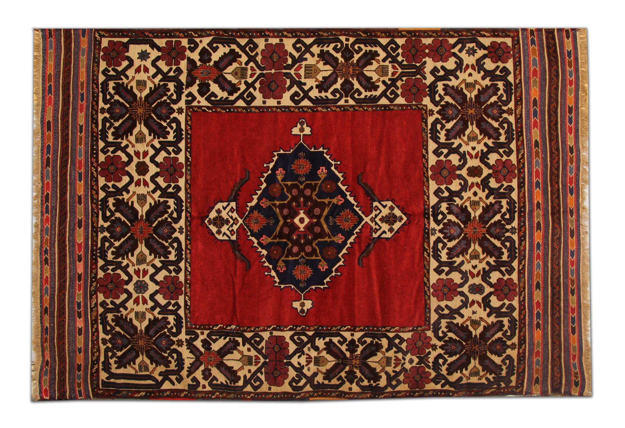 Featuring a highly detailed central medallion woven onto a red background. This is enclosed by a decorative repeat pattern floral motif border. Hand knotted with handspun, vegetable dyed wool and cotton this Vintage Afghan Area Rug is high quality