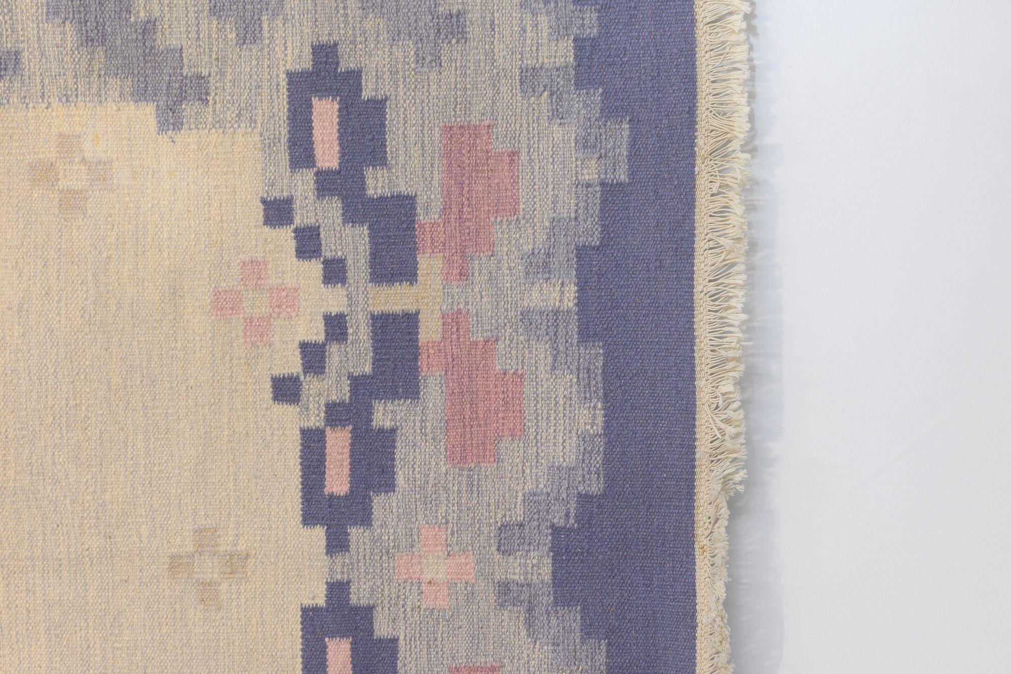 Grand kilim suédois du milieu du siècle dans les tons violet et crème. Nettoyé par des professionnels. Signé IJ. Tous nos tapis anciens sont soumis à un processus de nettoyage professionnel. Toutefois, en raison de leur âge et de leur vie