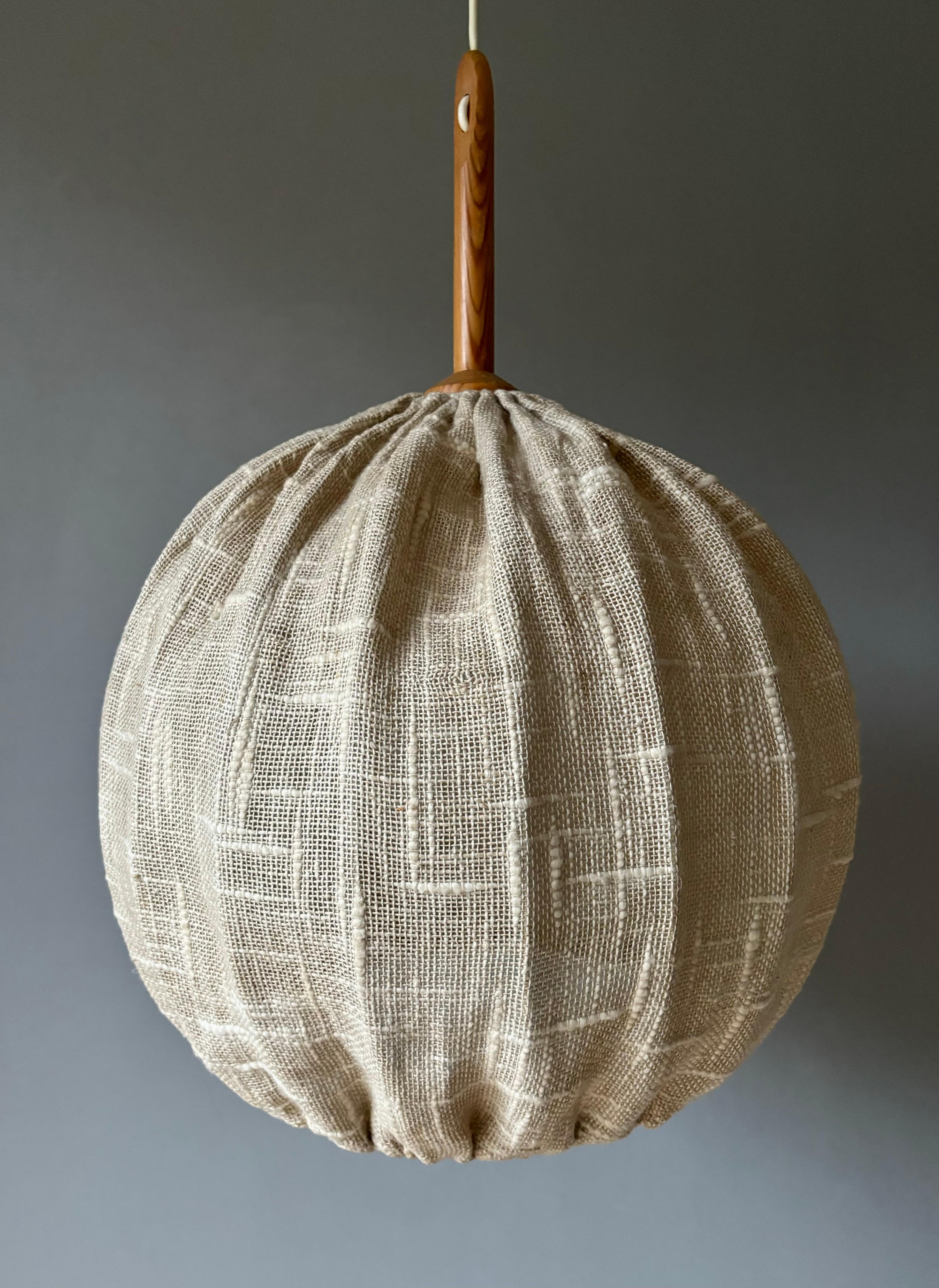 Handmade vintage Swedish midcentury modern globe shaped pendant manufactured in the 1960s. Natural sand colored rustic linen over circular white metal sphere mount. Textured cylinder glass insert keeping the heat from the bulb separated from the