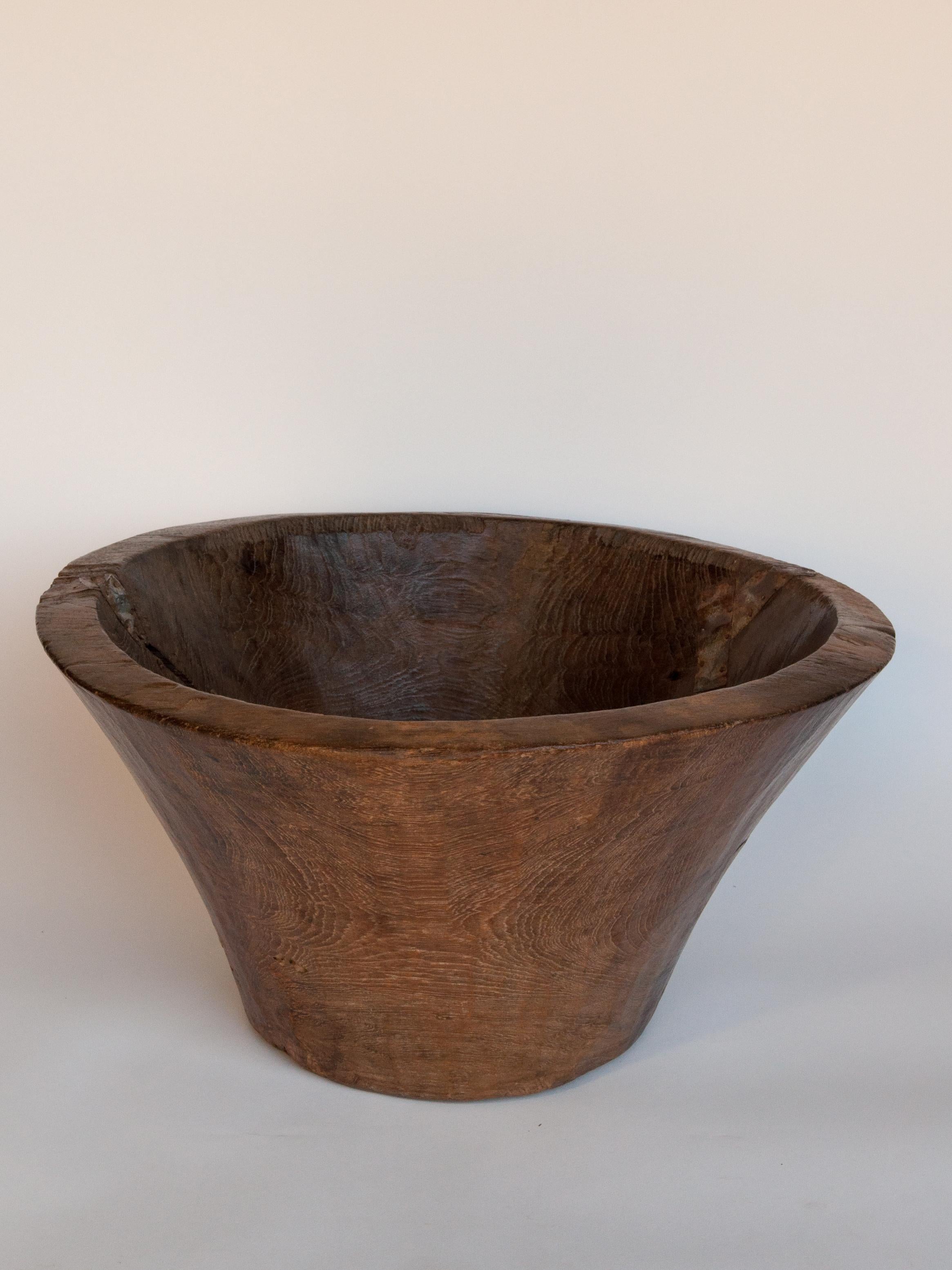 Large vintage teak bowl, hand hewn, from Cirebon, North Java, mid-20th century.
This rustic wood bowl was fashioned by hand from a single piece of teak wood and comes from the Cirebon area of Northern Java. It would have been used to offer foot or