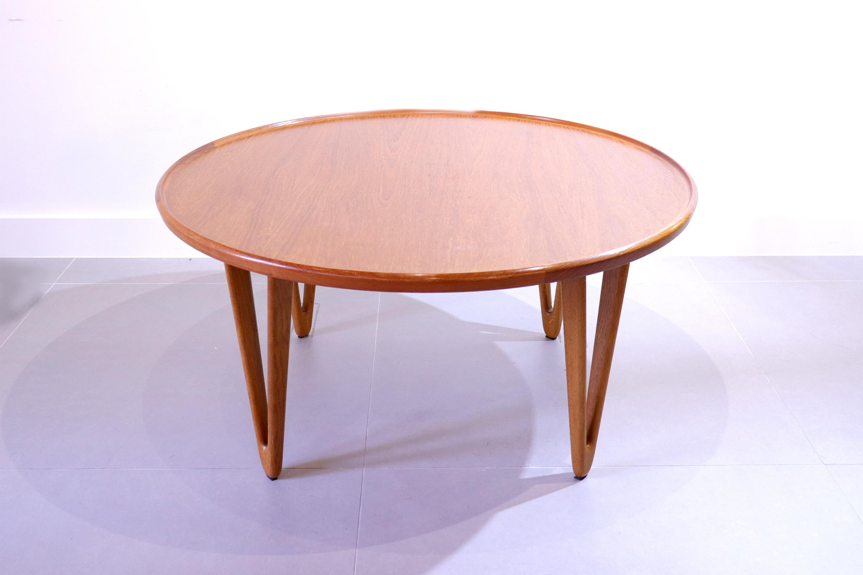 A rare round Danish 1950's coffee teak wood coffee table designed by husband and wife designers Tove Kindt - Larsen and Edvard Kindt - Larsen. 

The table features a large round sunken table top set on four sculptural hollow triangle teak legs which