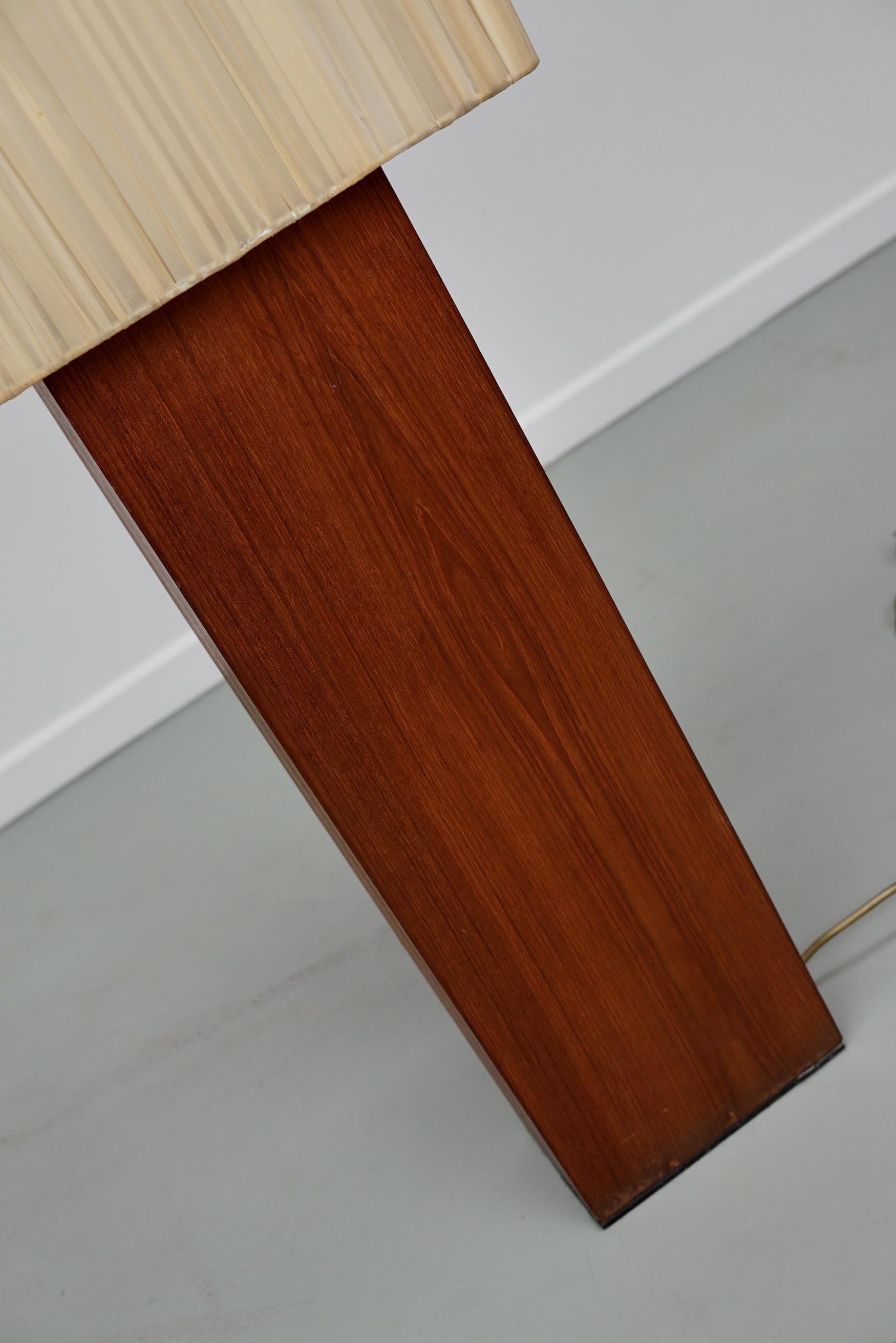 This vintage floor lamp was made around the 1960/70s. It features a square beige shade with four brass E27 fittings behind it. The shade is mounted on a teak veneered pillar. It remains in a good vintage condition.