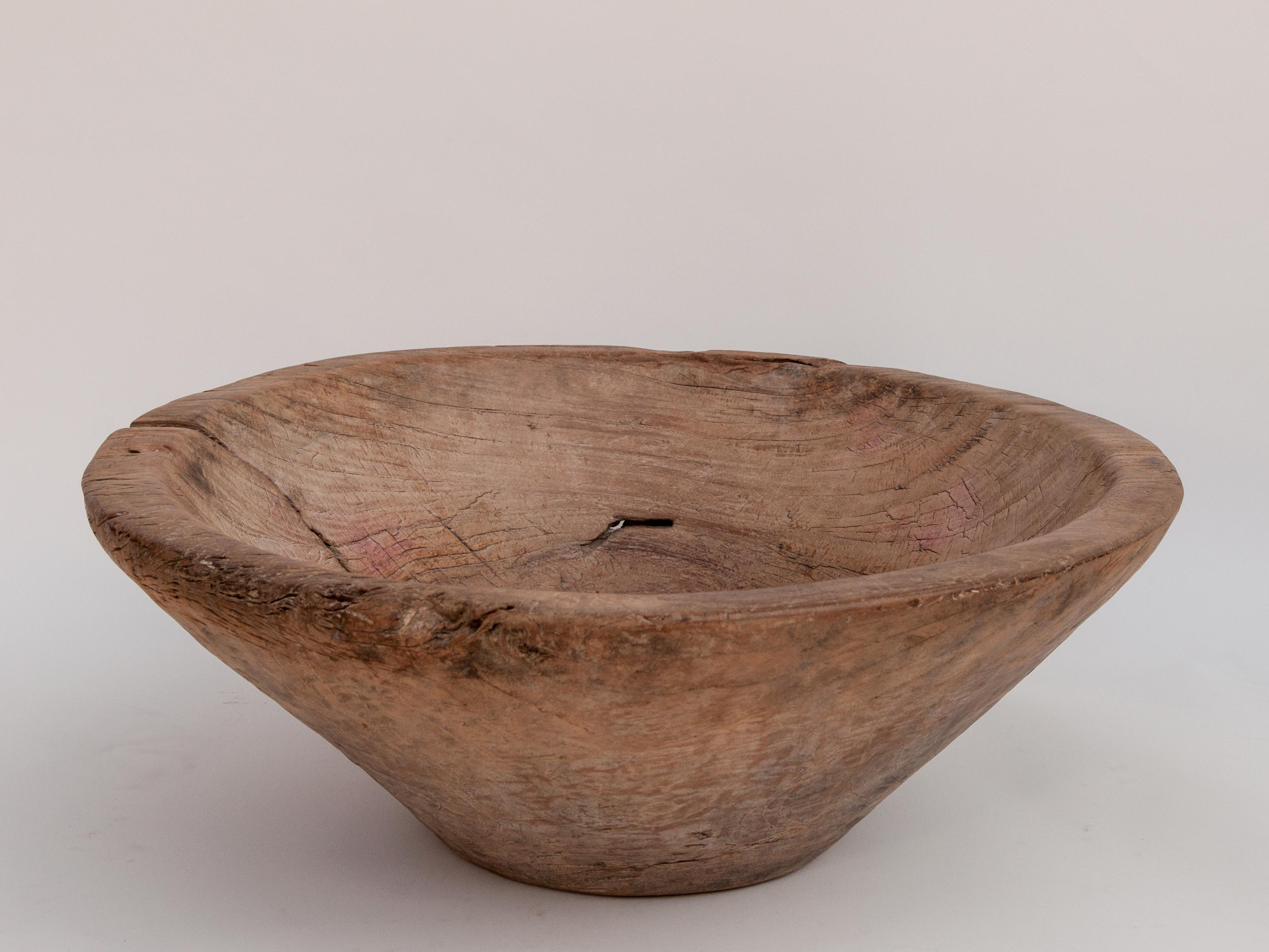 Large vintage teak wood bowl, 24 inch Diameter by 9 inches tall. From Cirebon, North Java, Mid-20th Century.
This rustic wood bowl was fashioned by hand from a single piece of teak wood and comes from the Cirebon area of Northern Java. It would