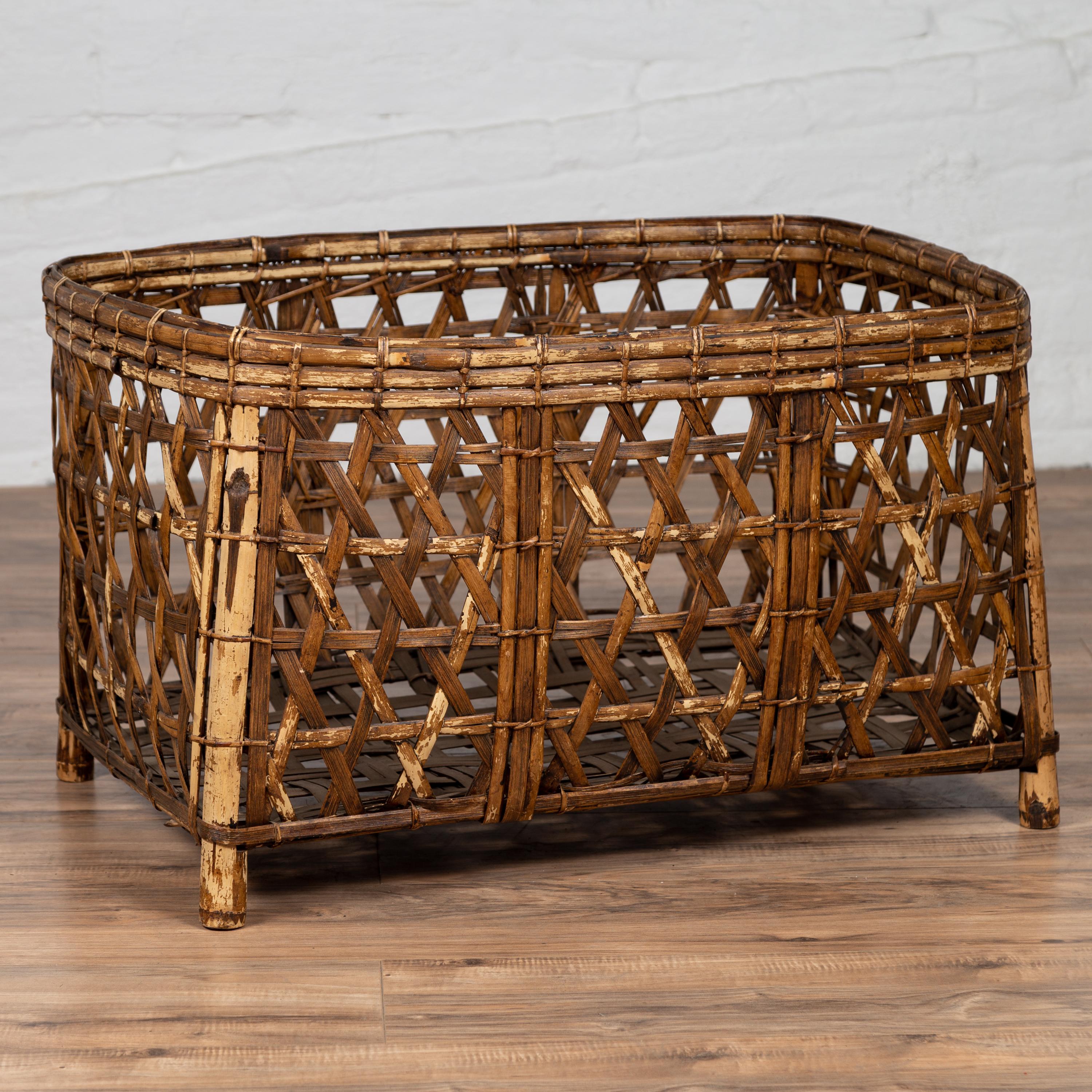 A large vintage bamboo fretwork basket from the mid-20th century, raised on short feet. This large vintage bamboo fretwork basket from the mid-20th century, raised on short feet, is a superb example of mid-century craftsmanship. Hand-crafted and