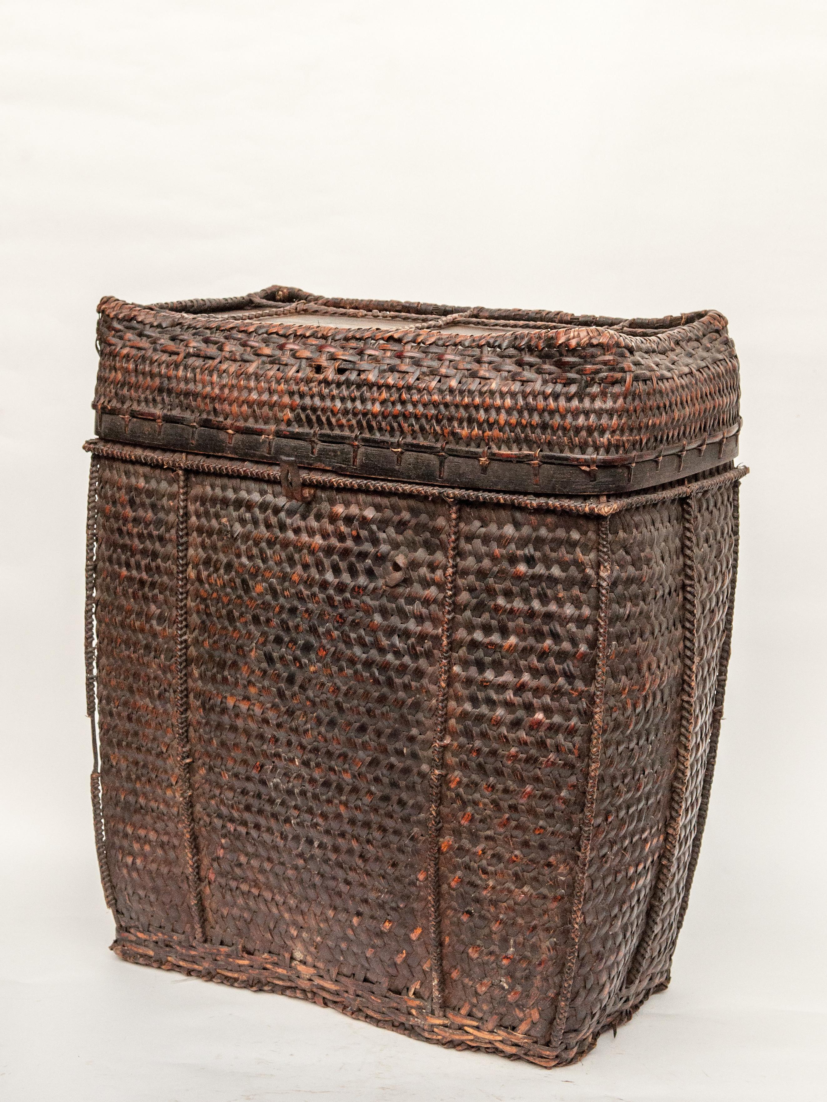 Large vintage tribal storage basket with lid from Bhutan, mid-late 20th century.
Handwoven of bamboo with wood incorporated into the base and top for added strength. This strong rustic basket would have been used to store household goods and